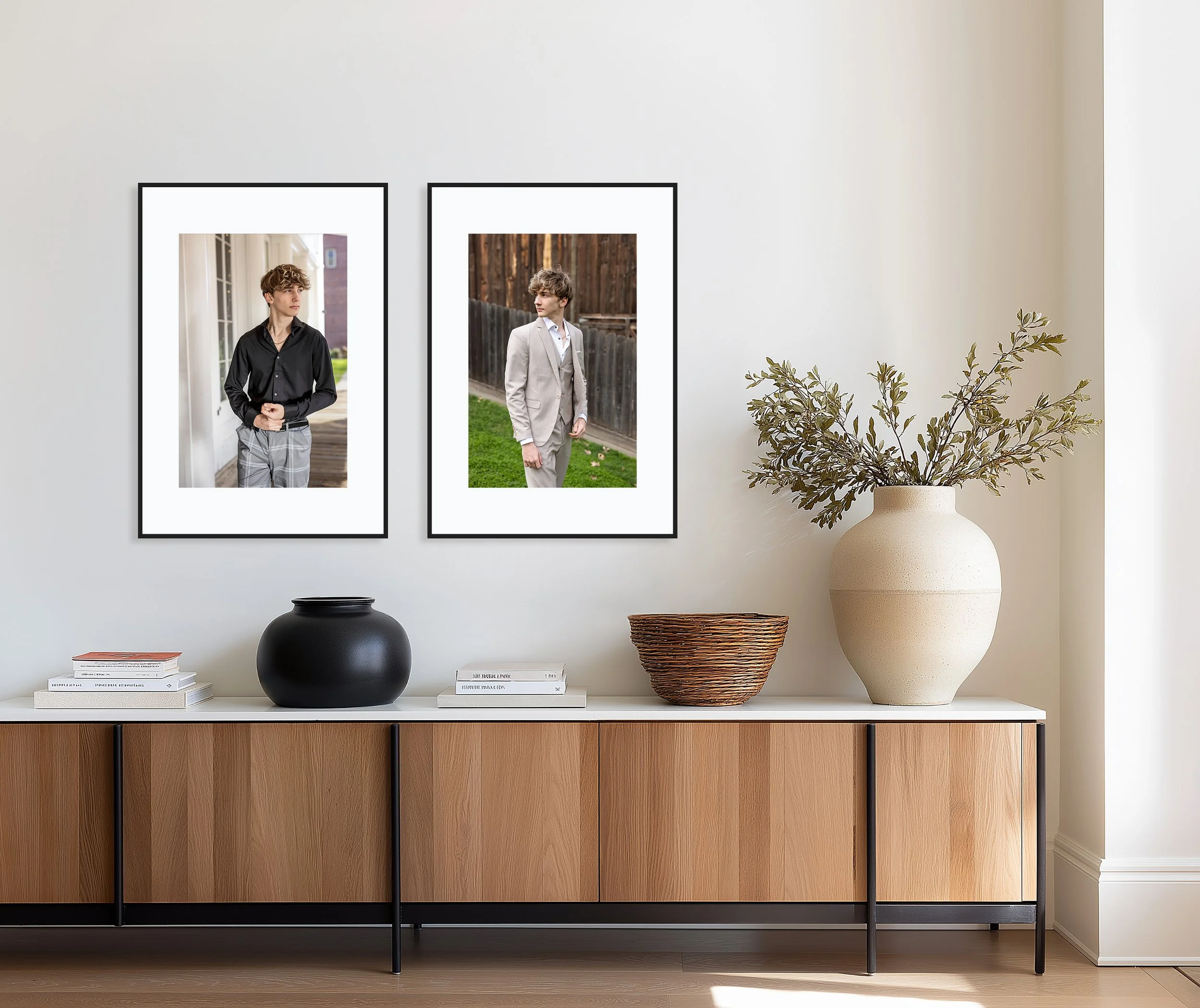 Sideboard with vases, books, and framed photographs, with potted plant on the right and a white wall background.