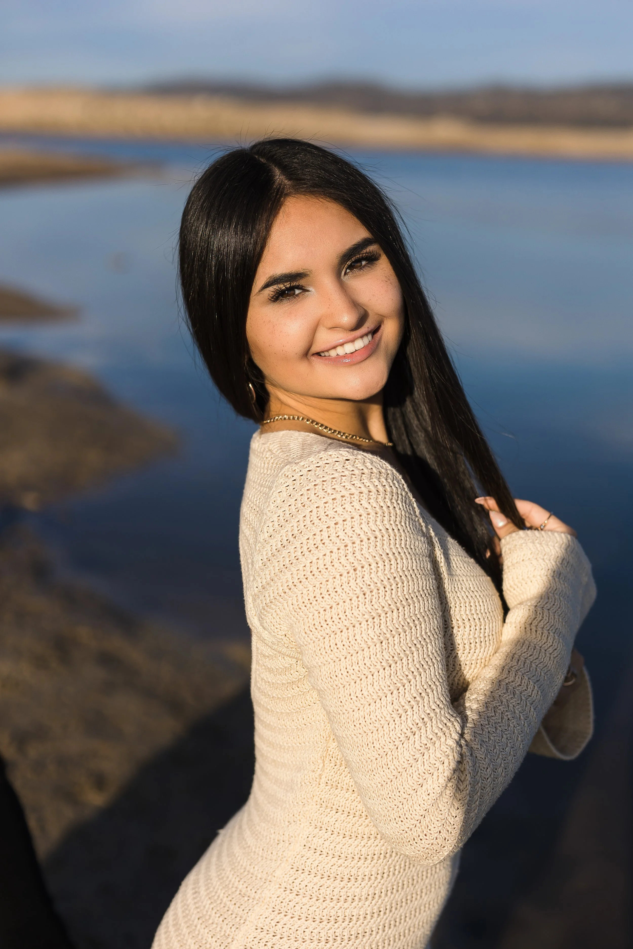 Granite Bay High School graduating senior smiling by Folsom Lake during her senior portrait session with a Northern California senior photographer.