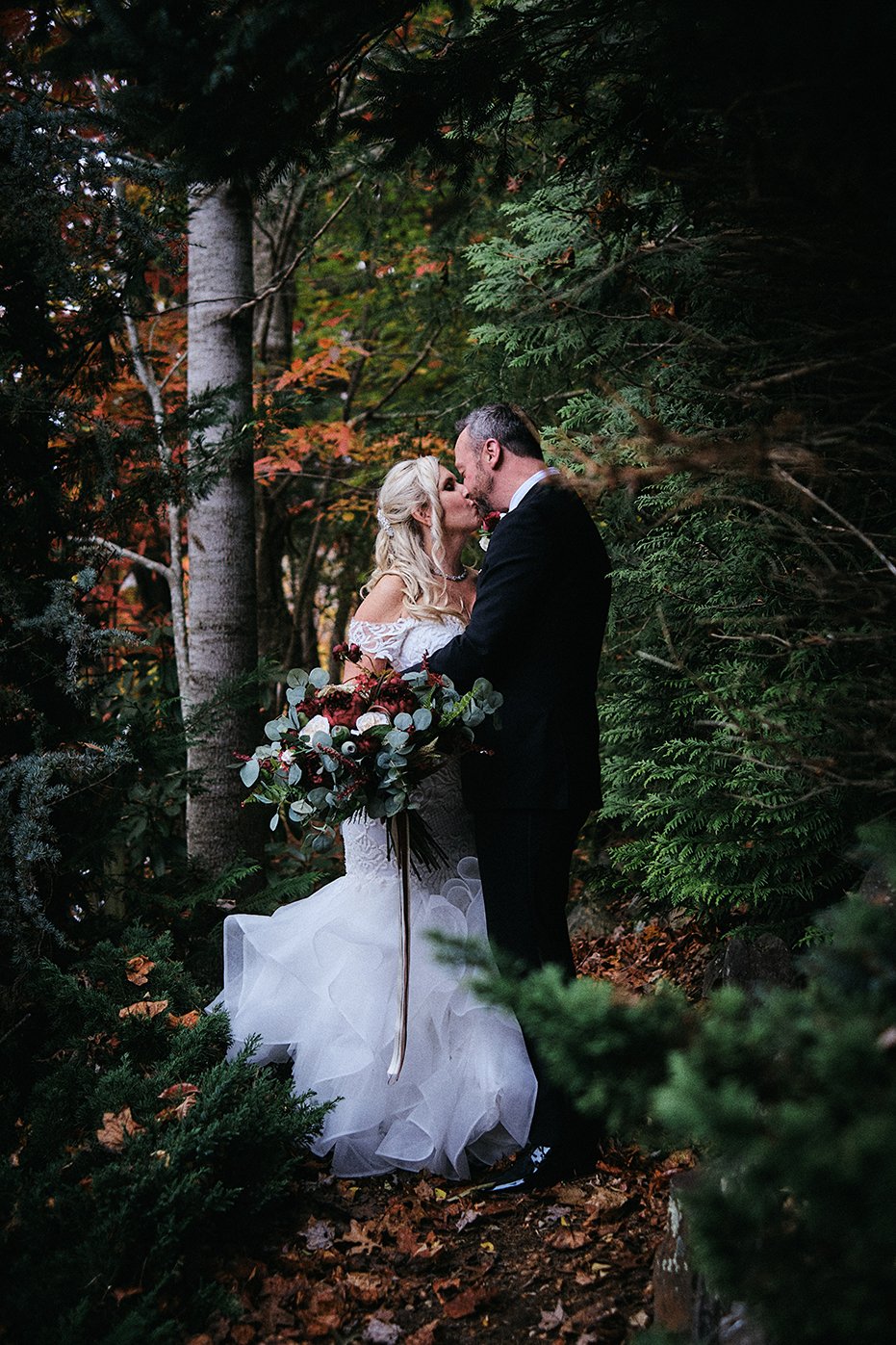 Couple sharing a kiss in an autumn forest during their intimate Appalachian elopement