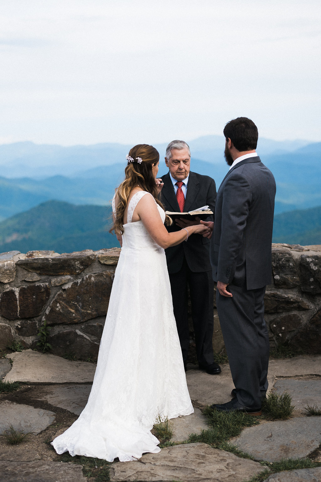 bride holds groom's hands