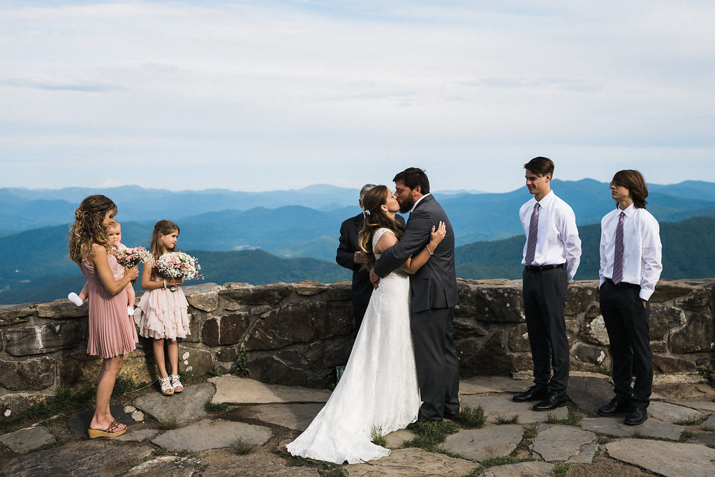 groom holds bride and kiss