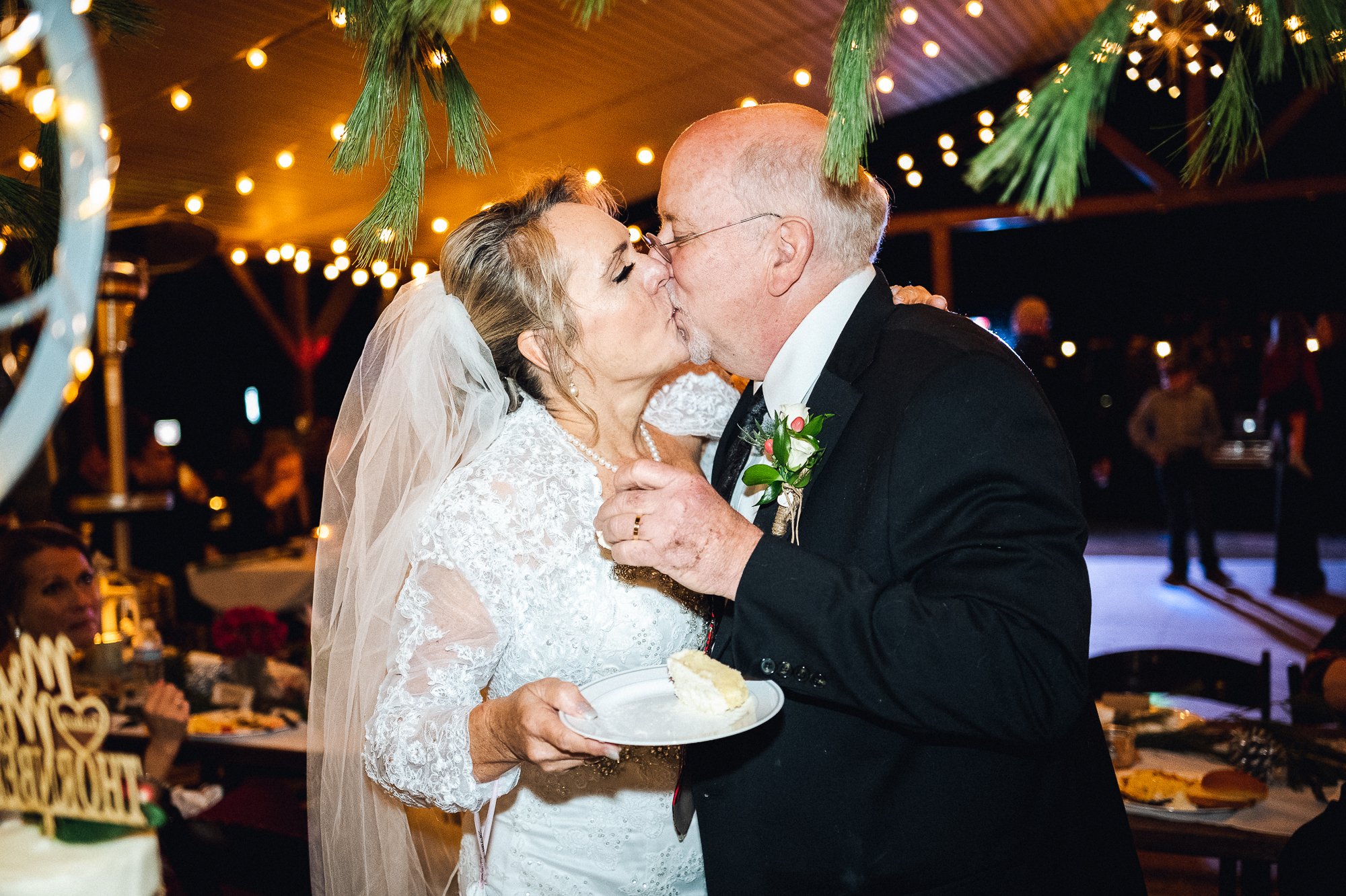 Kiss at the cake during reception at Nantahala Weddings and Events