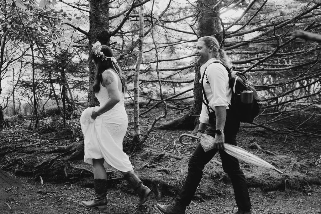 Carefree elopement couple walking in a grassy Roan Mountain meadow..jpg