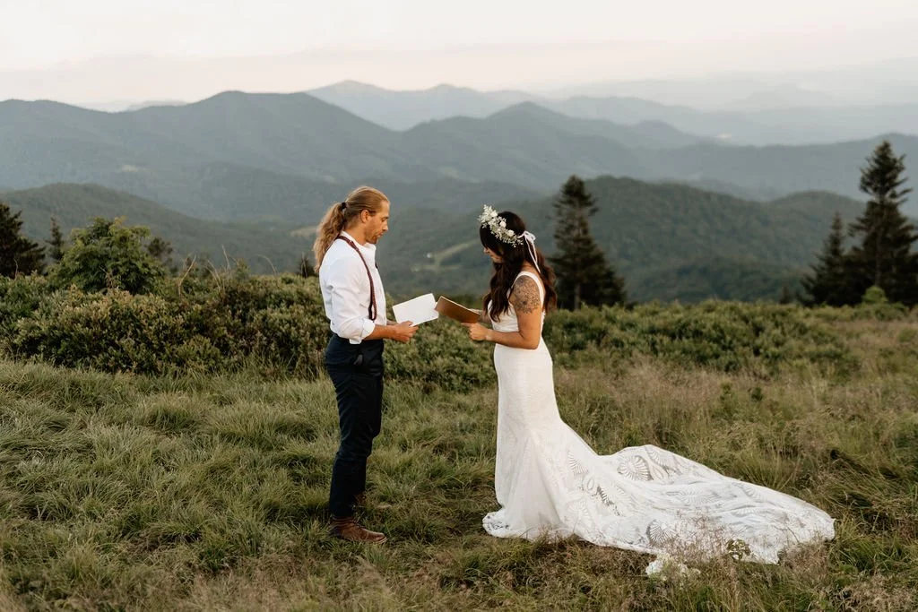 Emotional elopement moment—couple reading handwritten letters at sunrise on Roan Mountain..jpg