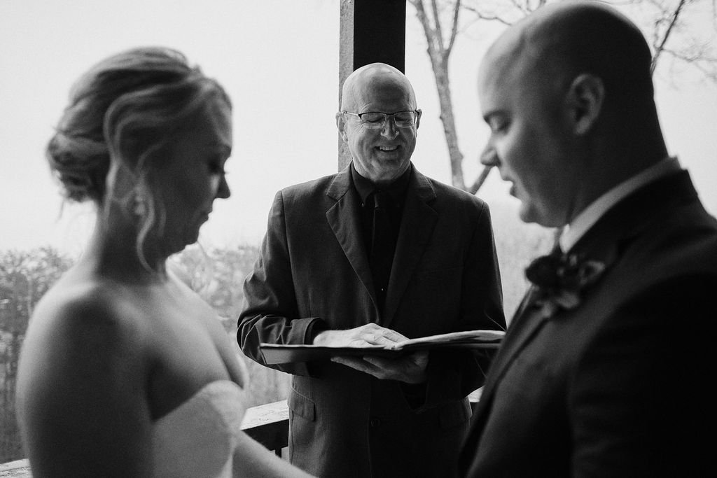 Black and white close-up of bride and groom exchanging vows during their intimate mountain wedding ceremony, Blue Ridge GA intimate wedding photographer