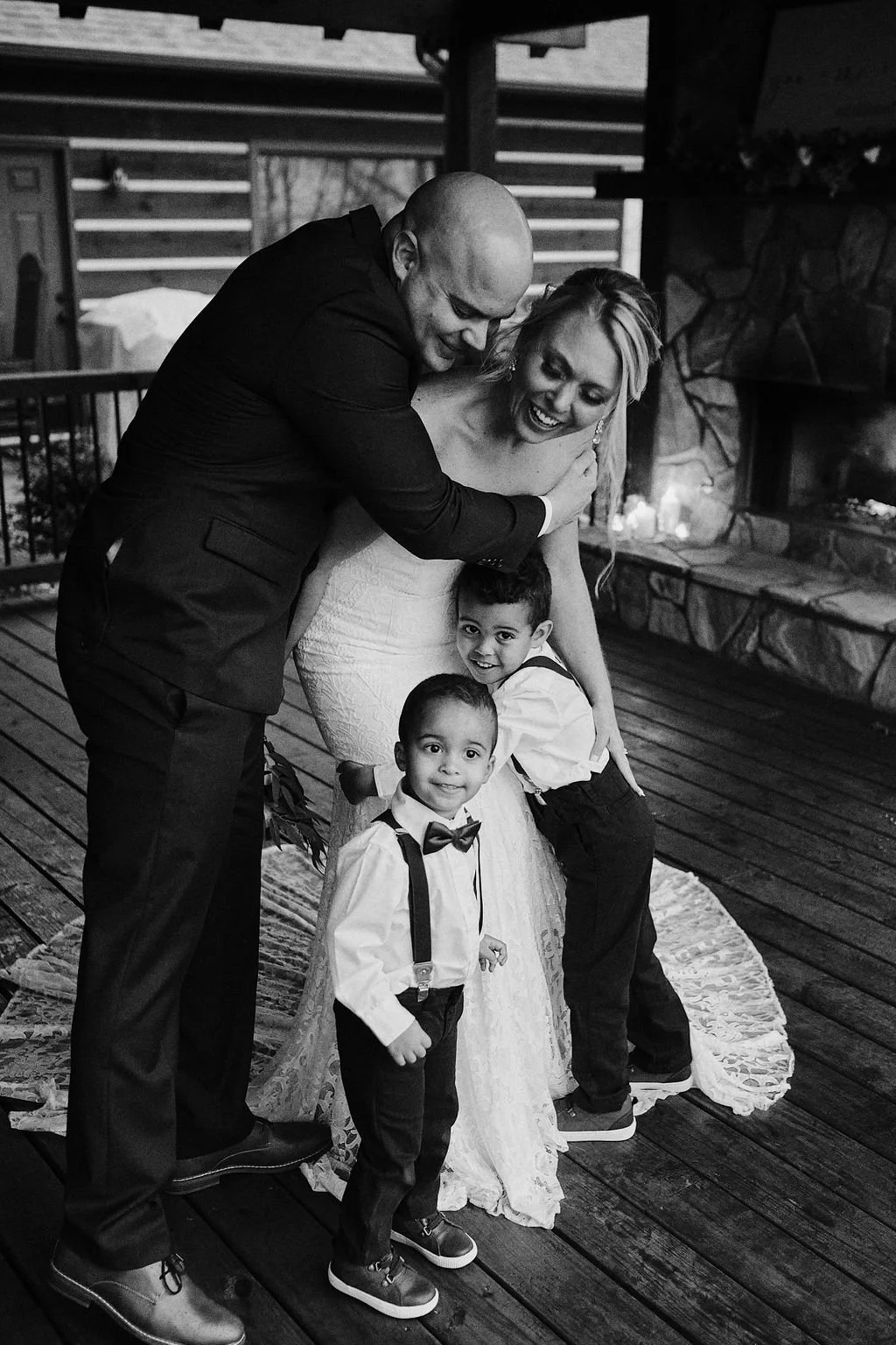 Black and white candid photo of family members sharing a group hug during Kissila and Doug's intimate Nantahala Forest elopement, Blue Ridge GA wedding photographer