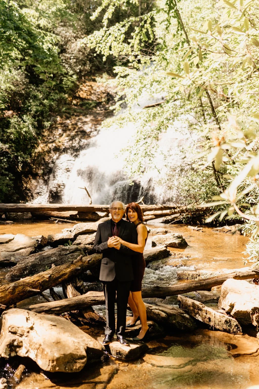 Couple portrait at Helton Creek Falls during their dawn elopement in Blue Ridge Georgia, soft morning light and waterfall backdrop, Appalachian Wedding Photography