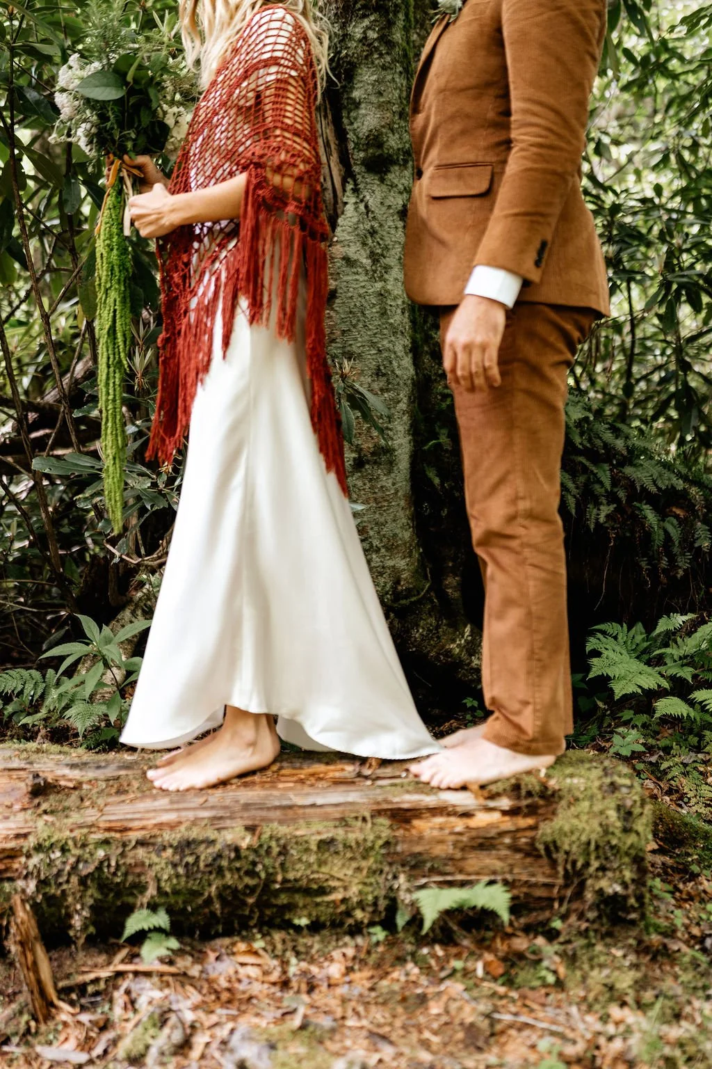 Hope and Chase standing barefoot on a mossy log surrounded by lush ferns in the Appalachian forest at Huffman Creek, Robbinsville, North Carolina