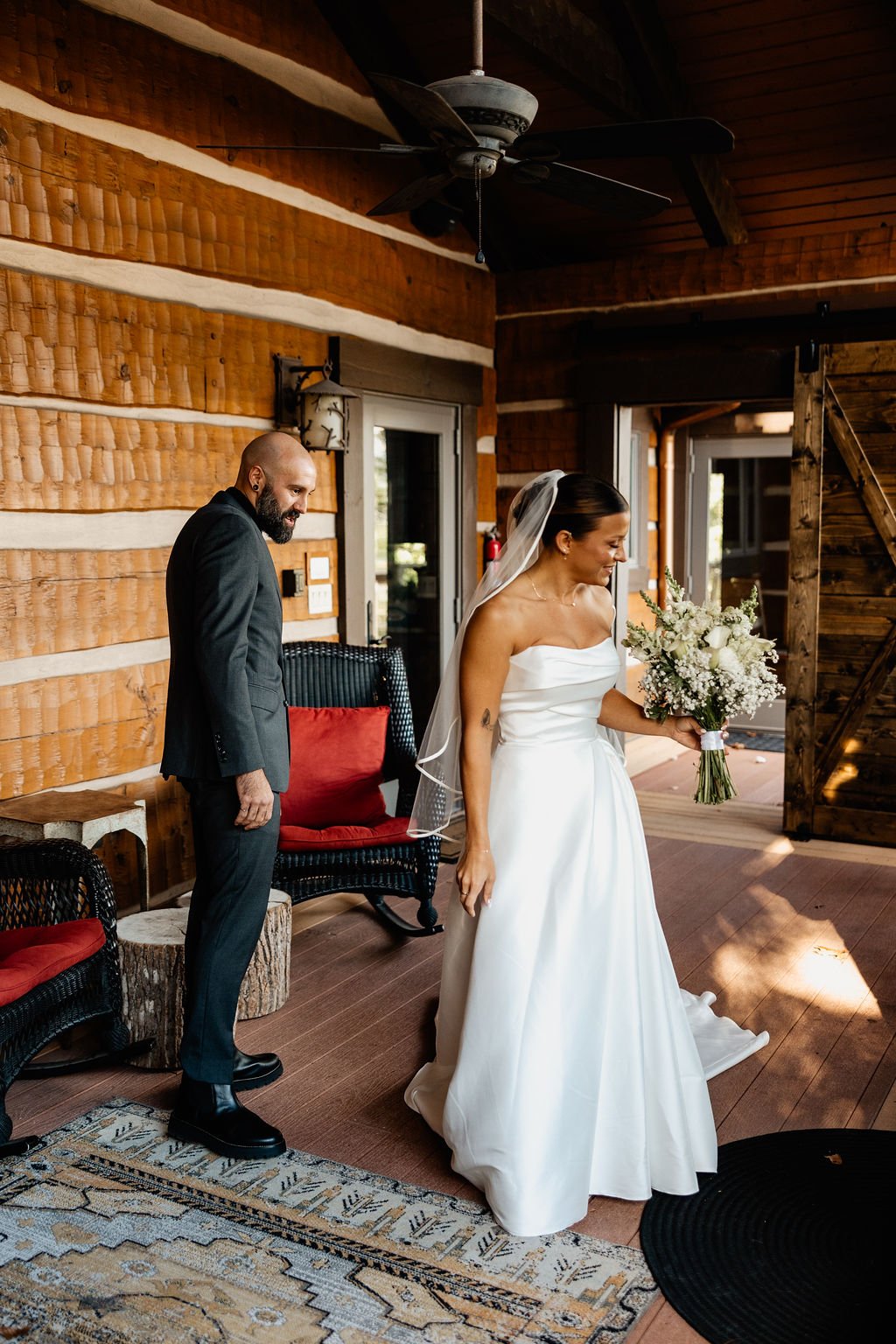 Bride Cayli holding her bouquet standing beside groom Jason at a rustic Blue Ridge Georgia mountain wedding venue, intimate cabin wedding photography by Appalachian Wedding Photography