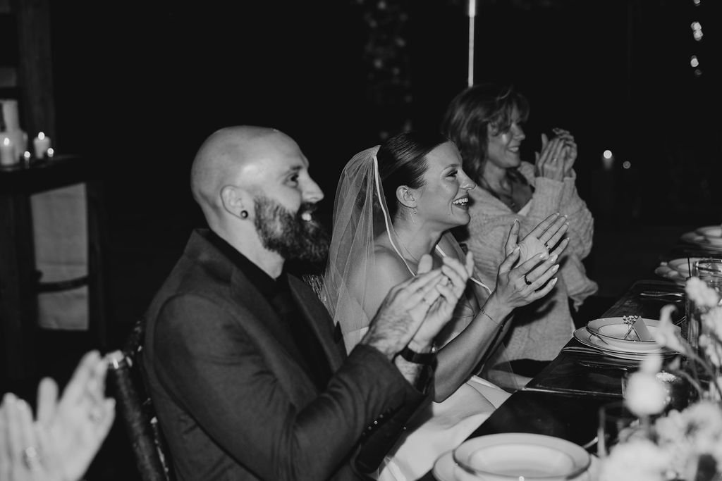 Bride Cayli and groom Jason clapping and celebrating together during their intimate Blue Ridge Georgia cabin wedding reception, photographed by Appalachian Wedding Photography