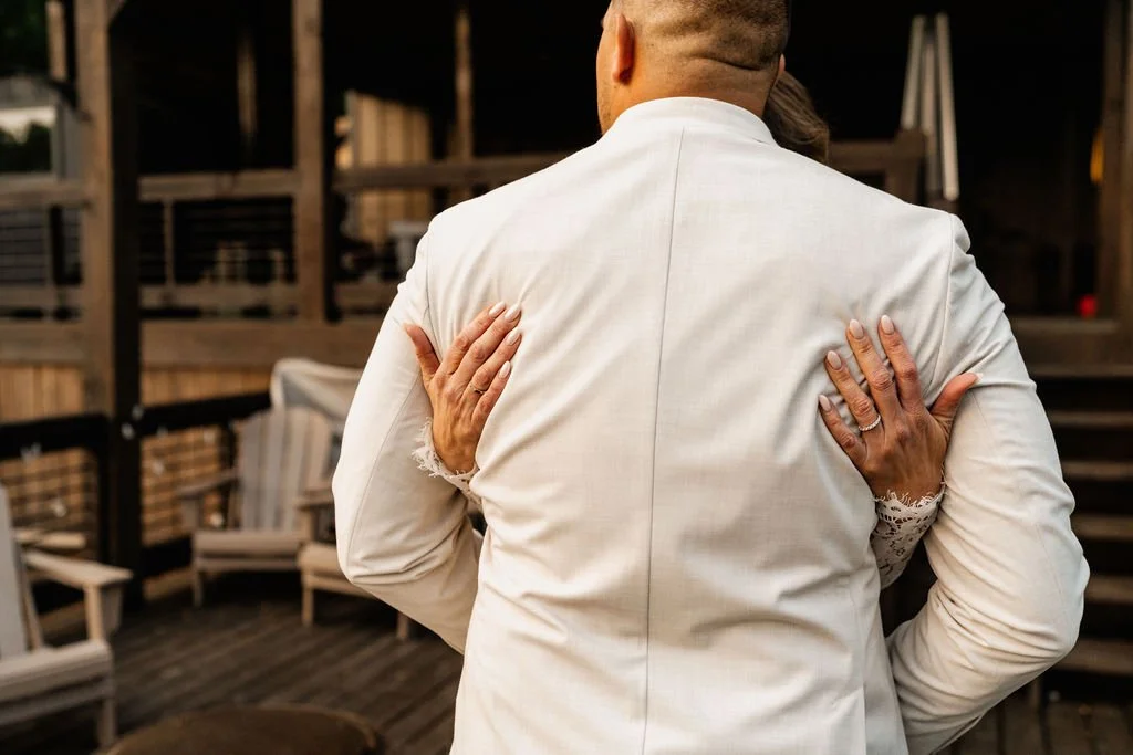 Erin's hands pressed flat against William's back with her wedding ring clearly visible during a tender post-ceremony embrace on the cabin deck during their Blue Ridge Georgia elopement