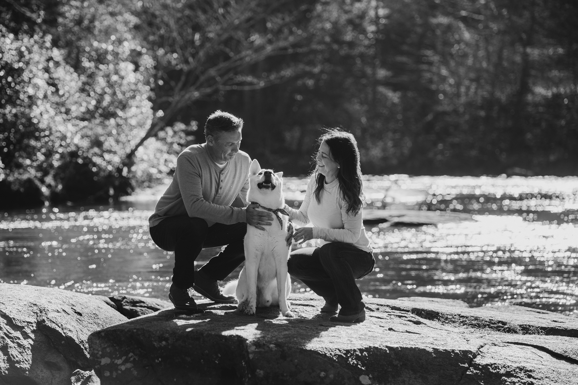 Couple Caressing their Dog on the River Rocks at Blue Ridge Georgia by Appalachian Wedding Photography