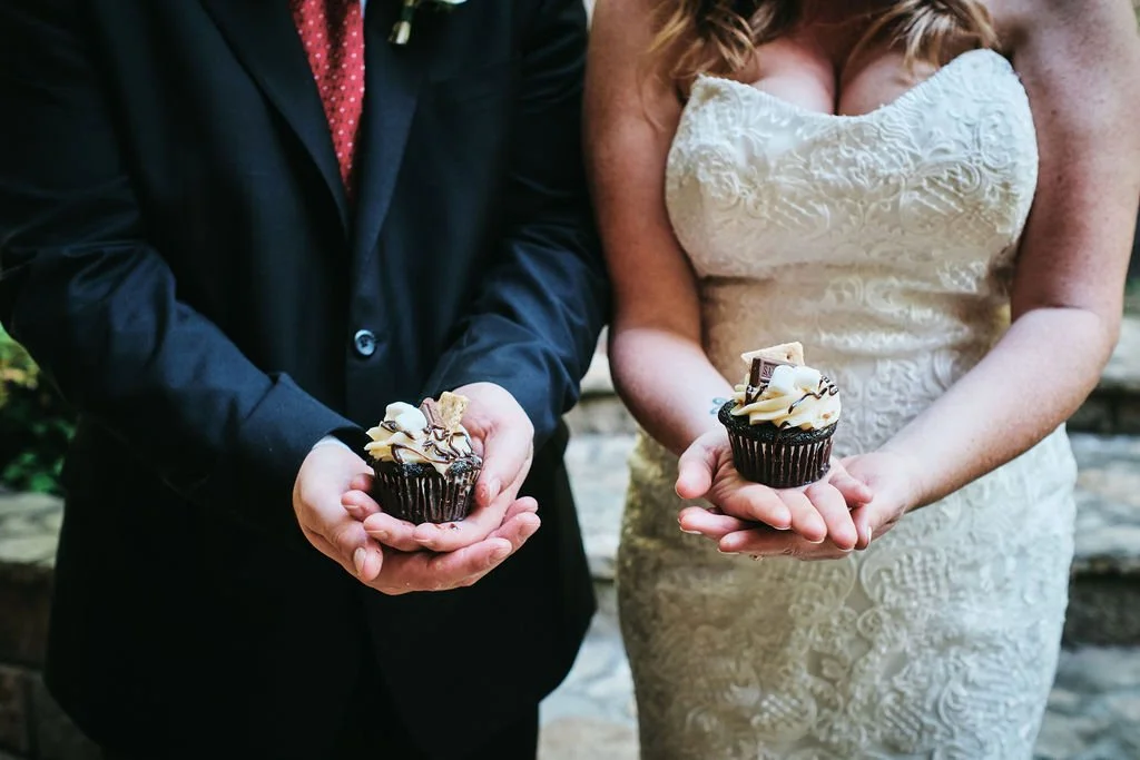 Vickie and Cody each holding a chocolate s'mores cupcake in their palms during their Blue Ridge Georgia elopement