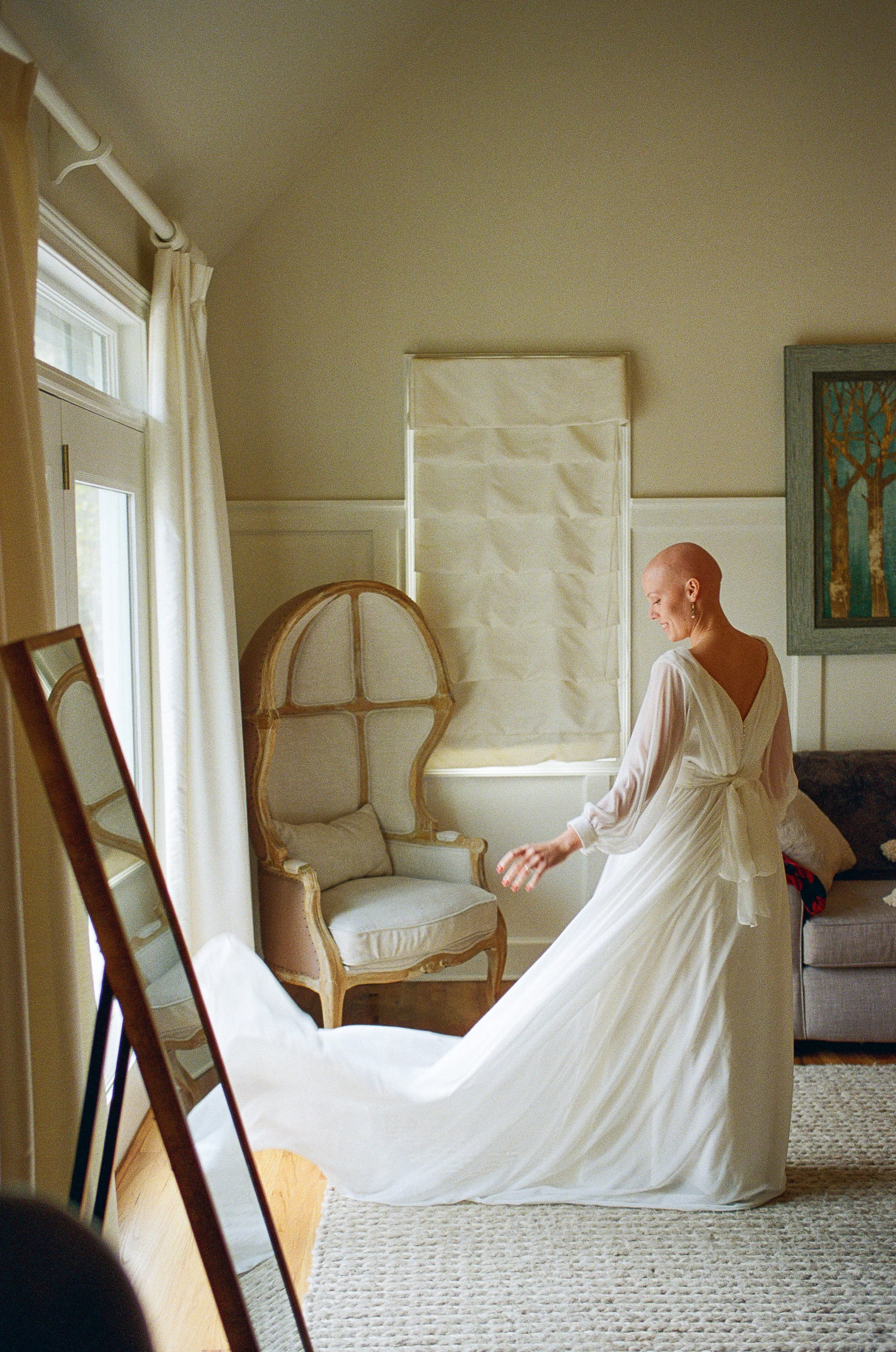 Bride in a flowing gown getting ready in a vintage room before her Appalachian wedding