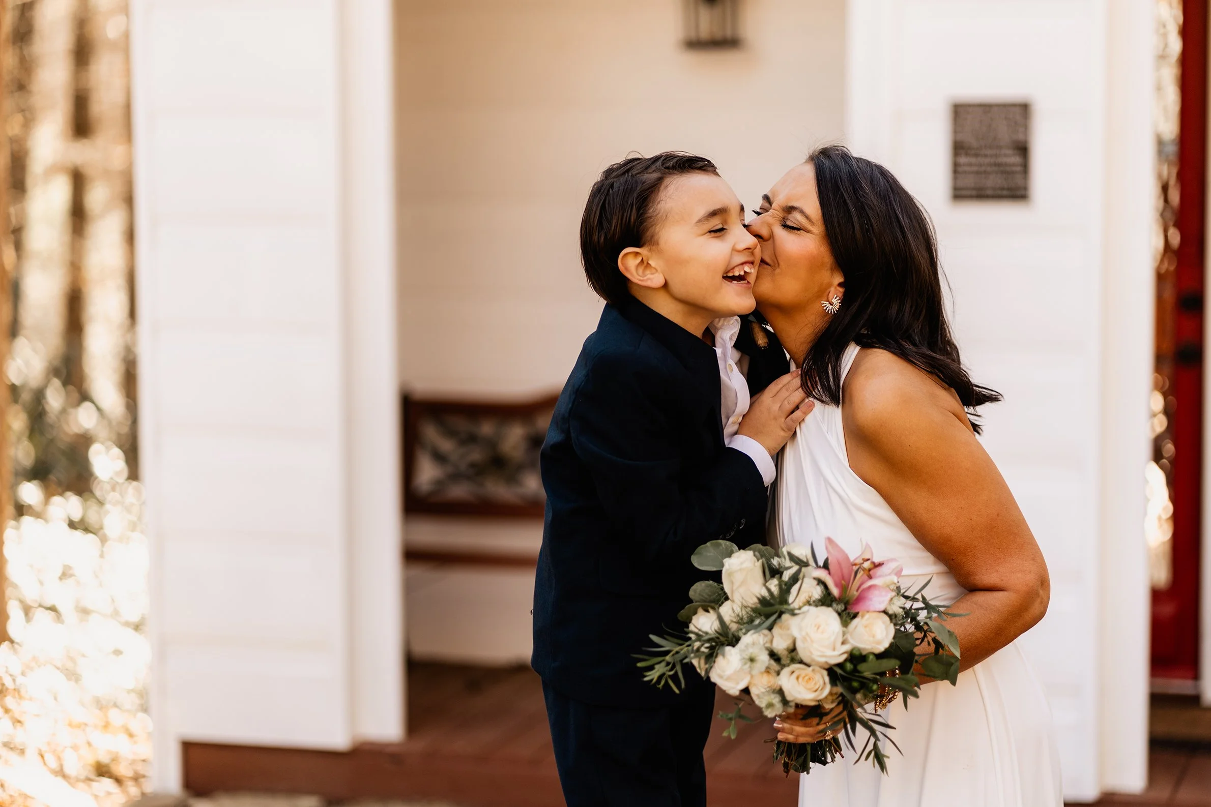 Dylan and Shelley sharing an intimate indoor elopement moment with mother's kiss in Blue Ridge, Georgia