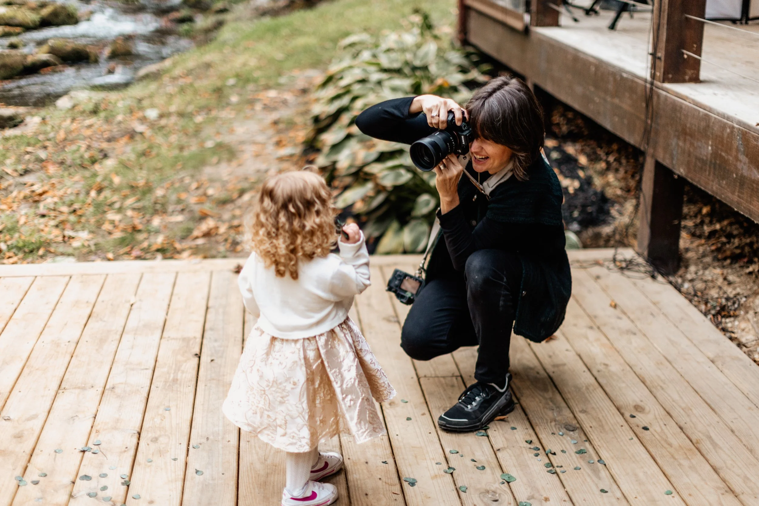 Emilie Gates taking a picture of a child at mountain wedding in the Blue Ridge Georgia area by Appalachian Wedding Photography