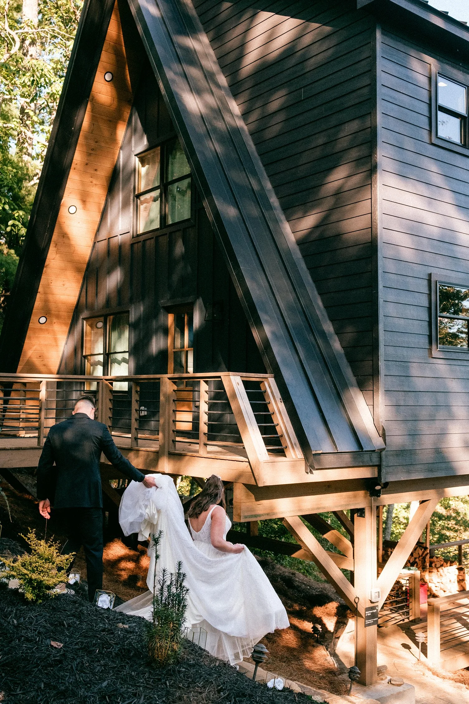Couple posing in front of an A-frame cabin during their Blue Ridge, Georgia mountain elopement