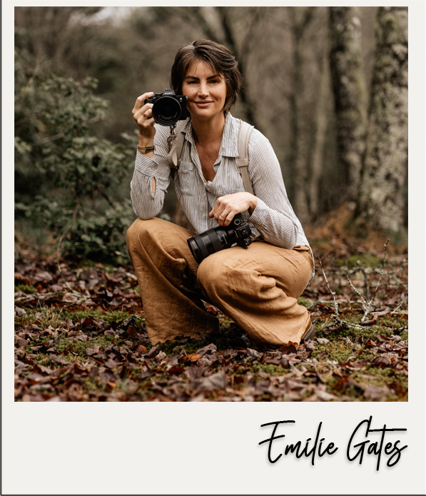 Emilie Gates Sitting in a squat position holding two cameras.png