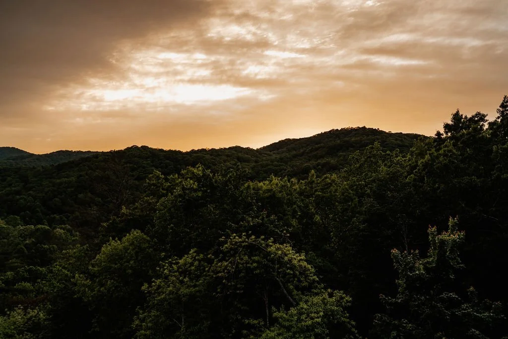 Golden sunset sky glowing over an Appalachian mountain ridgeline and forest, Blue Ridge Georgia wedding photography by Emilie Gates