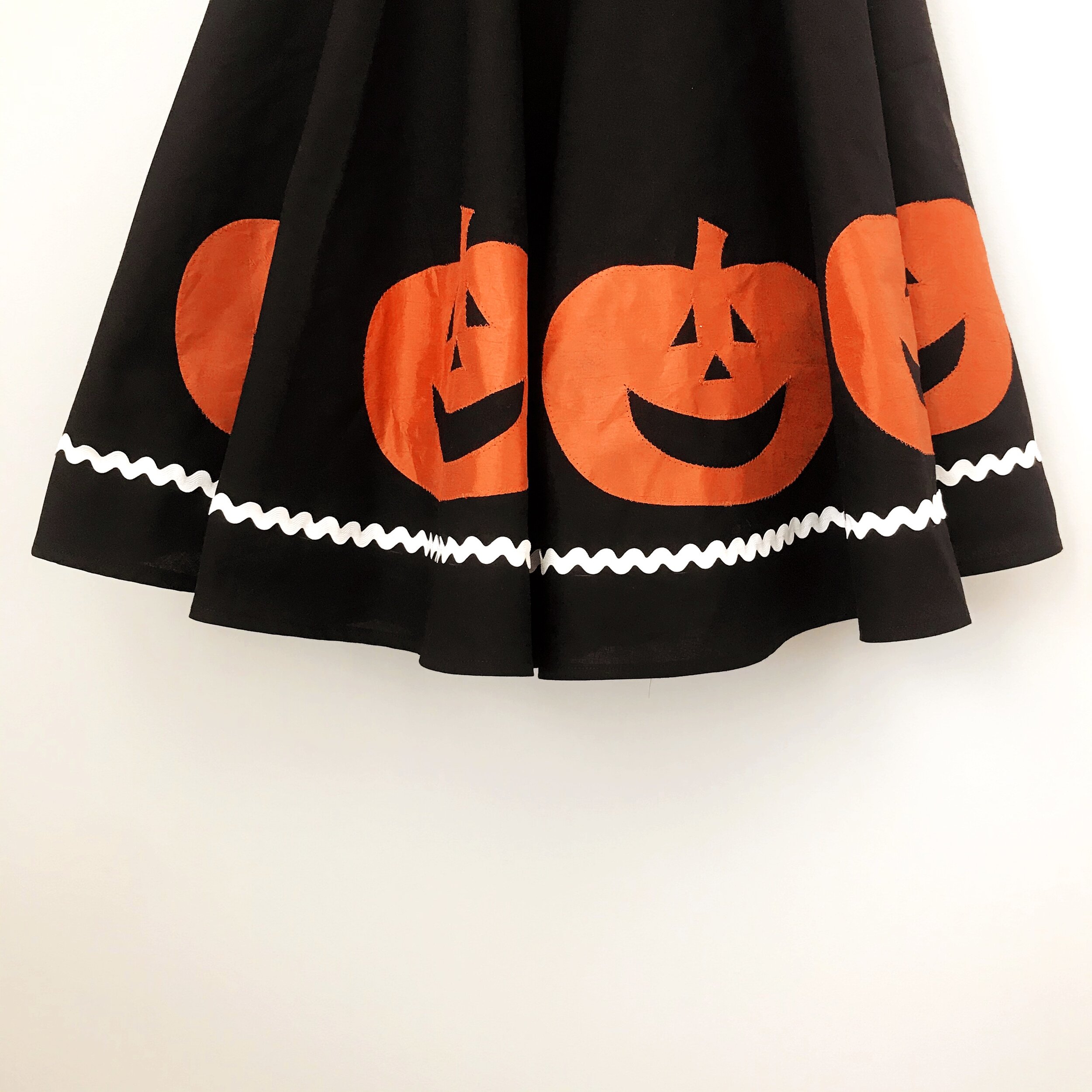 black circle skirt with orange pumpkins and white rick rack trim that is sewn on