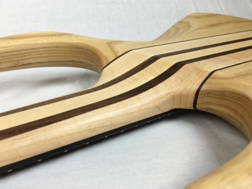 "N eck through designs are found in true high-end stringed instruments. The whole guitar is stronger and can handle more abuse. The neck woods extend from the headstock (with no scarf joint) through the center of the body. This is where the majority of the instrument's tone is created. This feature helps produce unmatched tone and sustain. This also keeps the instruments in tune and intonated better and keeps smooth continuous playability when reaching the high notes without interference of a clumsy heel or bolt on neck."