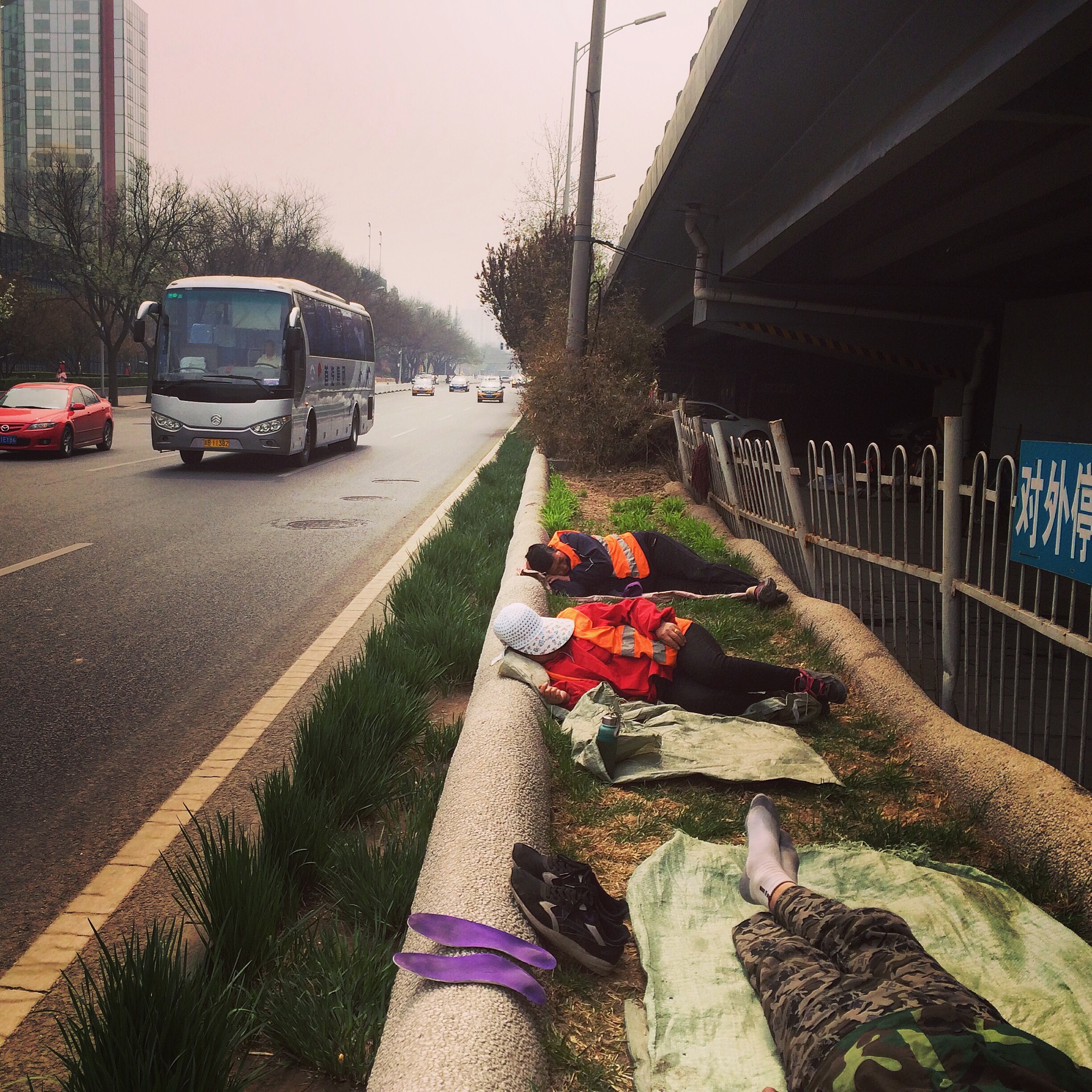 Street sweepers take a nap beside the Third Ring Road, Beijing.