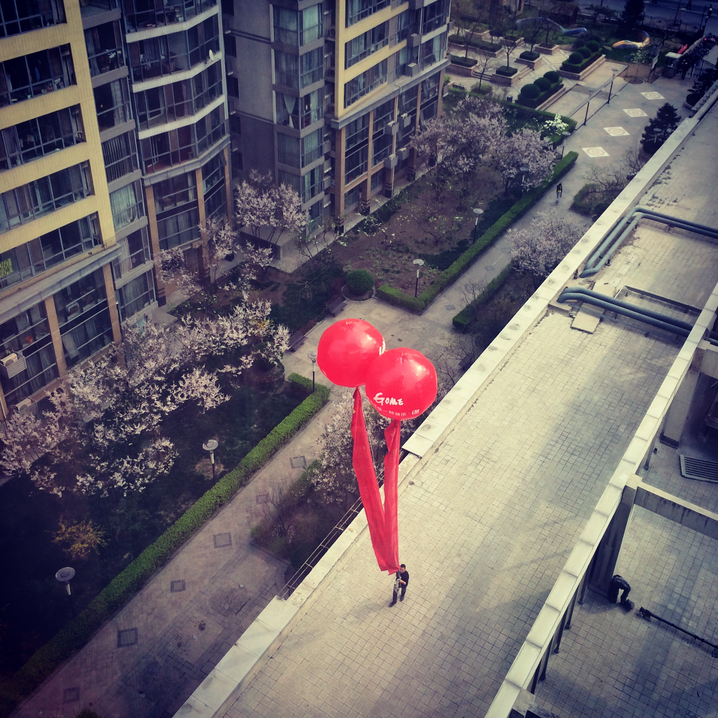 A man carrying giant balloons advertising a supermarket, Beijing.