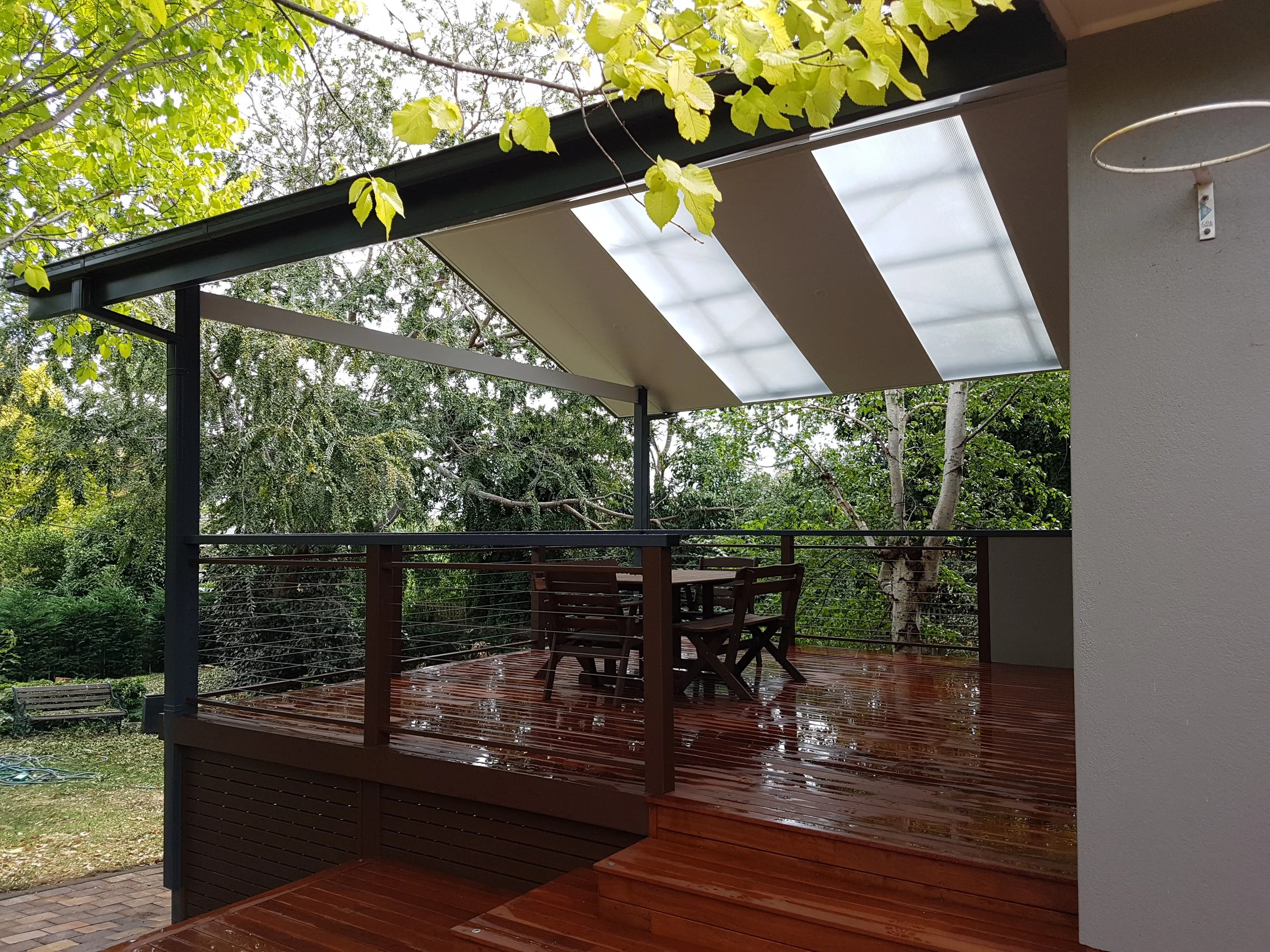 Gable pergola with skylight panels. Metal balustrade with stainless steel wires, and Merbau decking