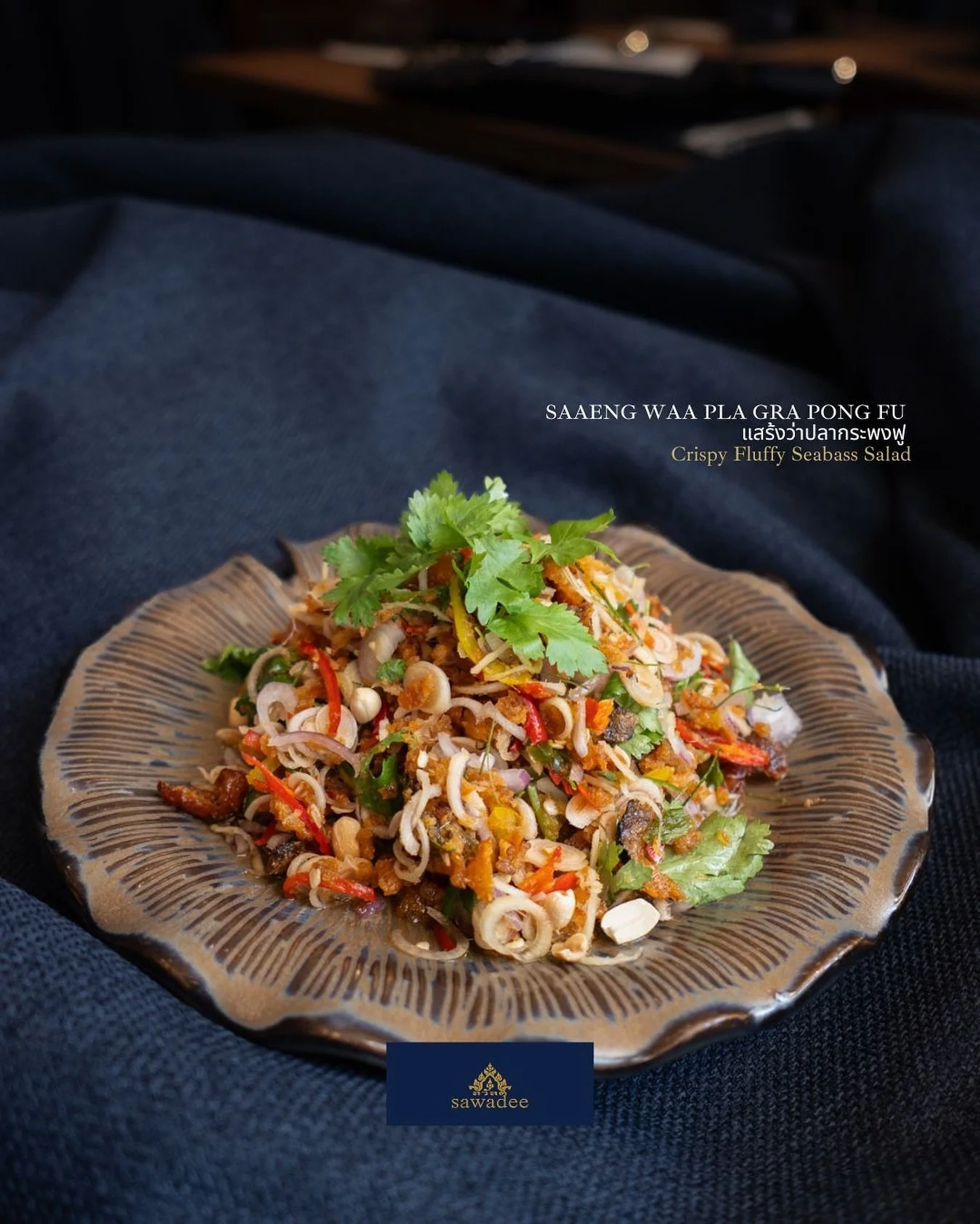Crispy Fluffy Seabass Salad (แสร้งว่าปลากระพงฟู) is a seasonal crowd favourite, a salad made from crispy-fried seabass tossed in a zesty Thai dressing and topped with crispy lemongrass, creating the perfect balance of texture and tang.

This elegant 