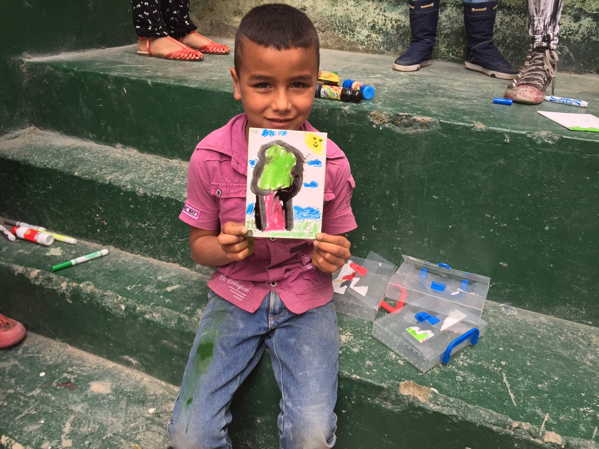 Boy at orphanage showing off art work.