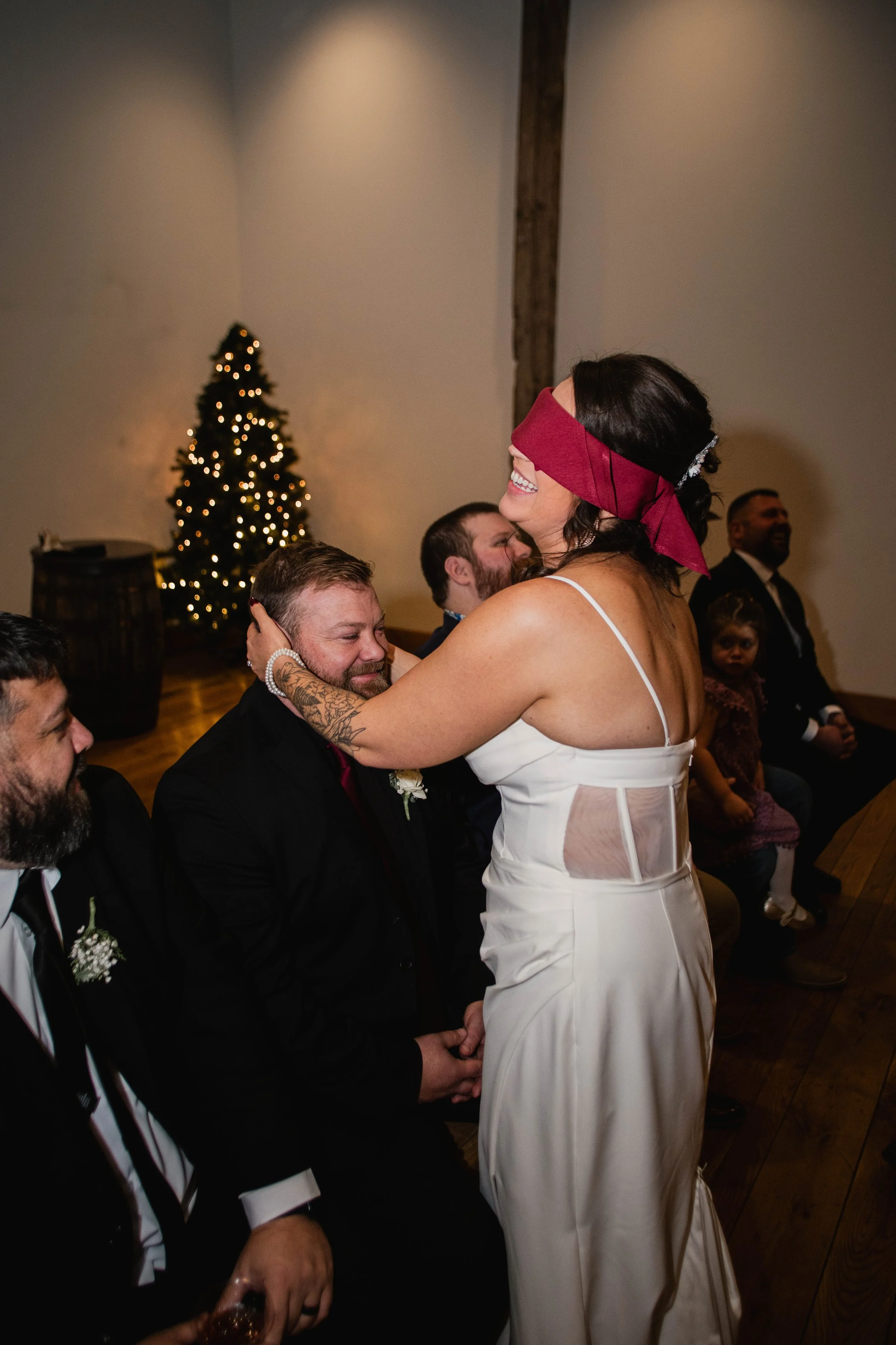 Blindfolded bride Kelsey feeling beards to find her husband during a wedding reception game at The Landing Event Center in Loveland, Ohio.