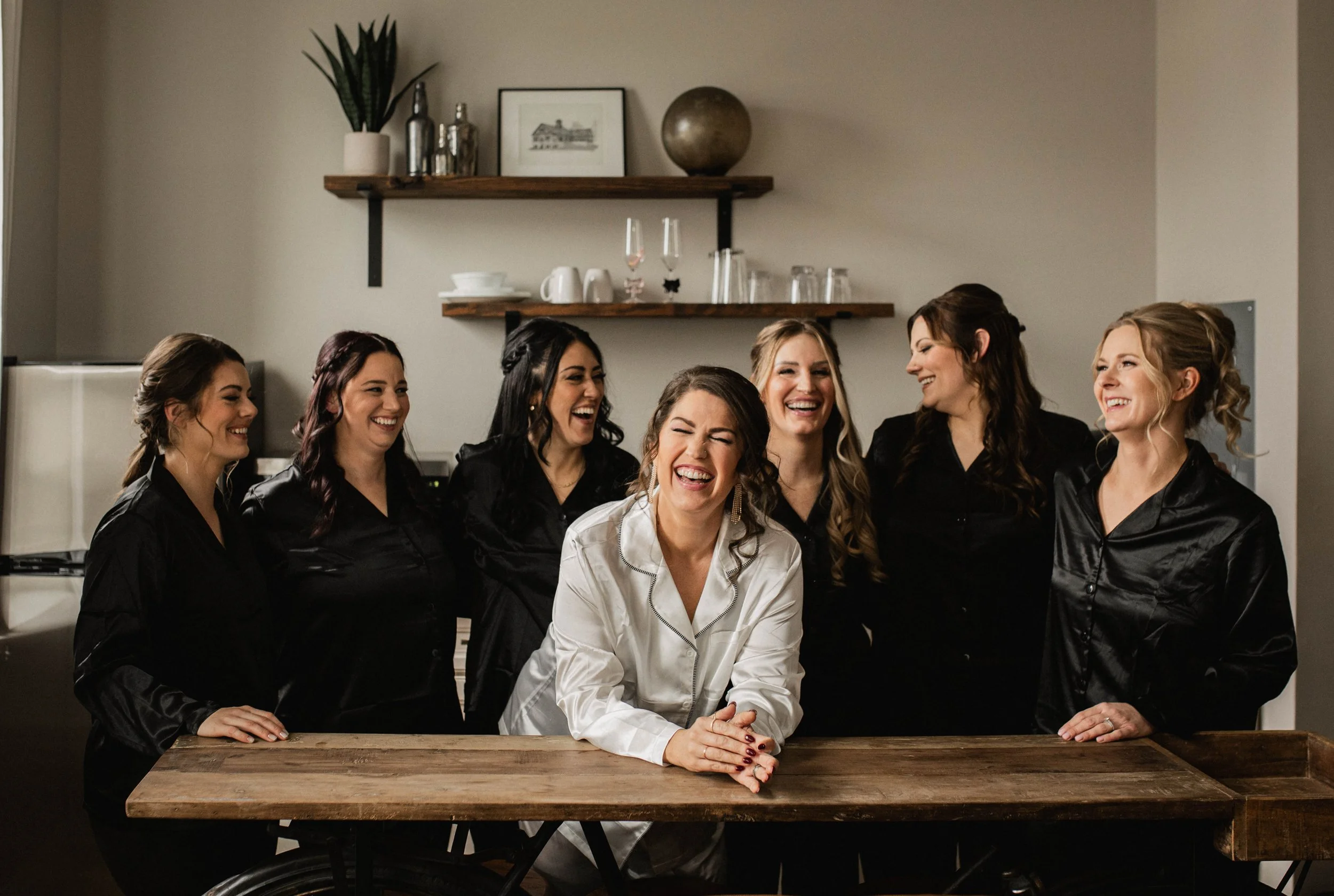 Bride and bridesmaids sharing a laugh while getting ready for a wedding at The Landing Event Center in Loveland, Ohio.
