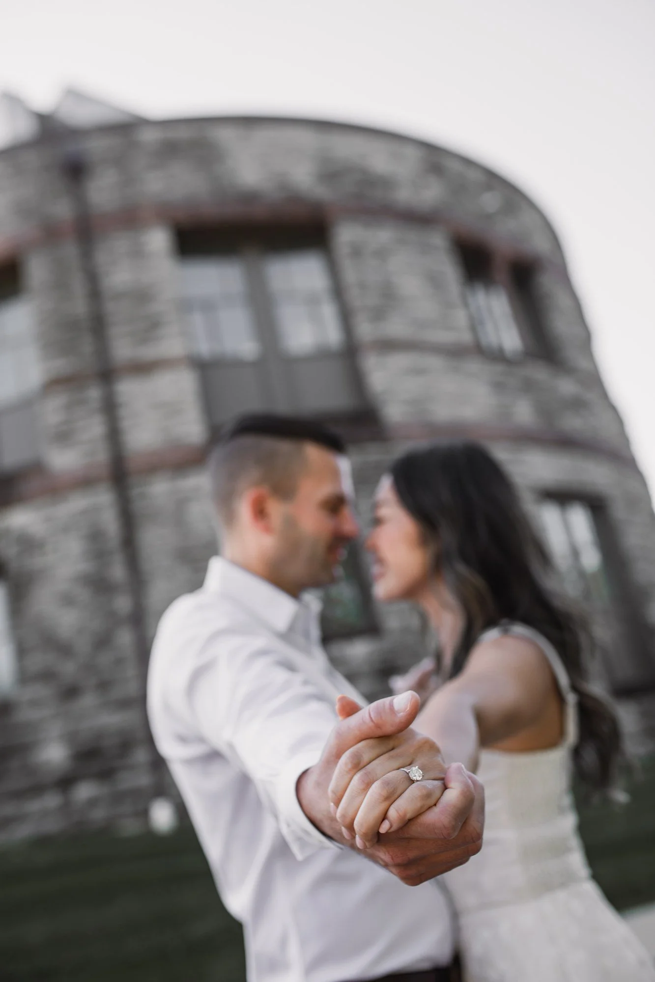 Kitty and Scott leaning close with their joined hands in the foreground and the museum’s curved stone facade behind them.