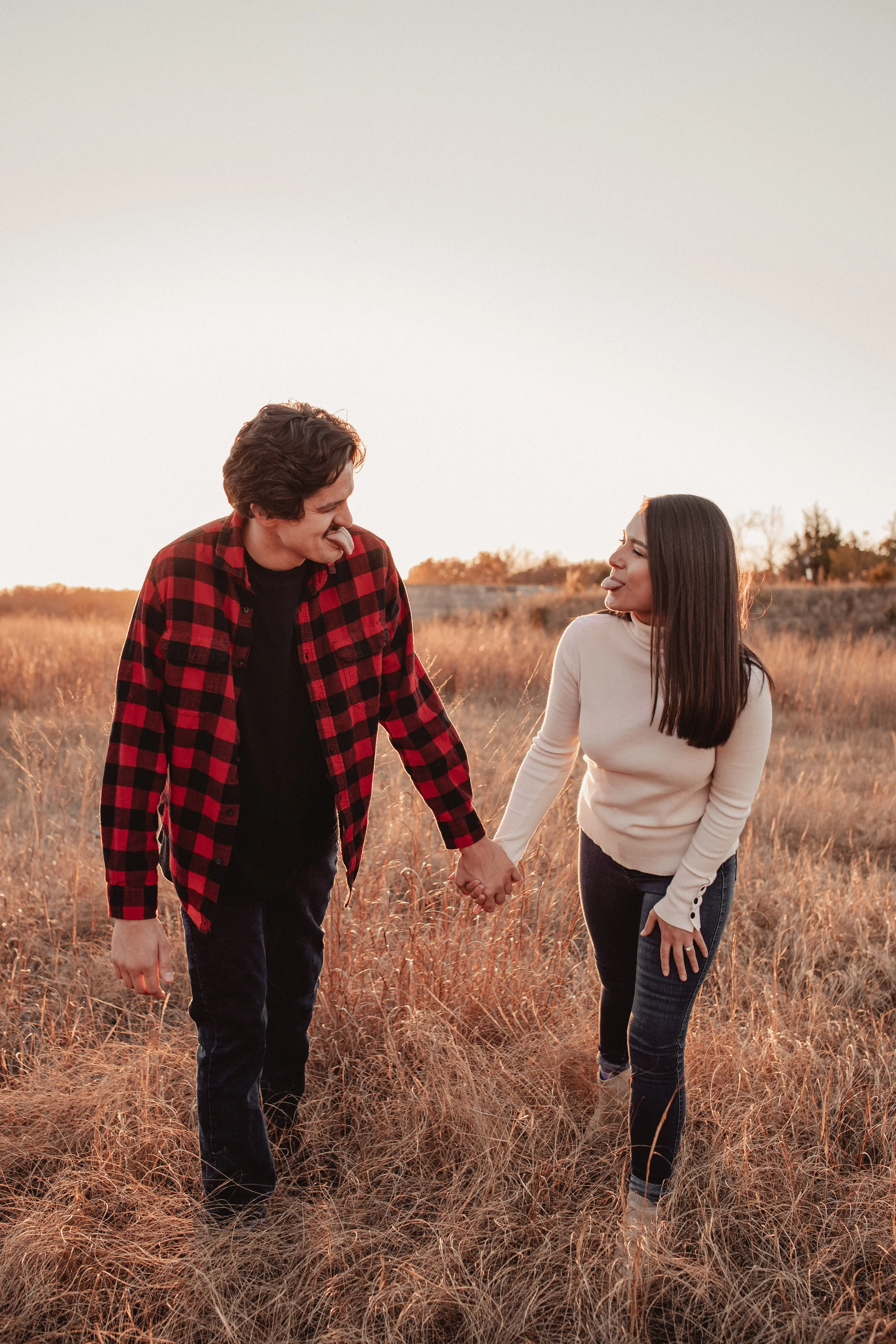 Engagement session in a field at a sunset