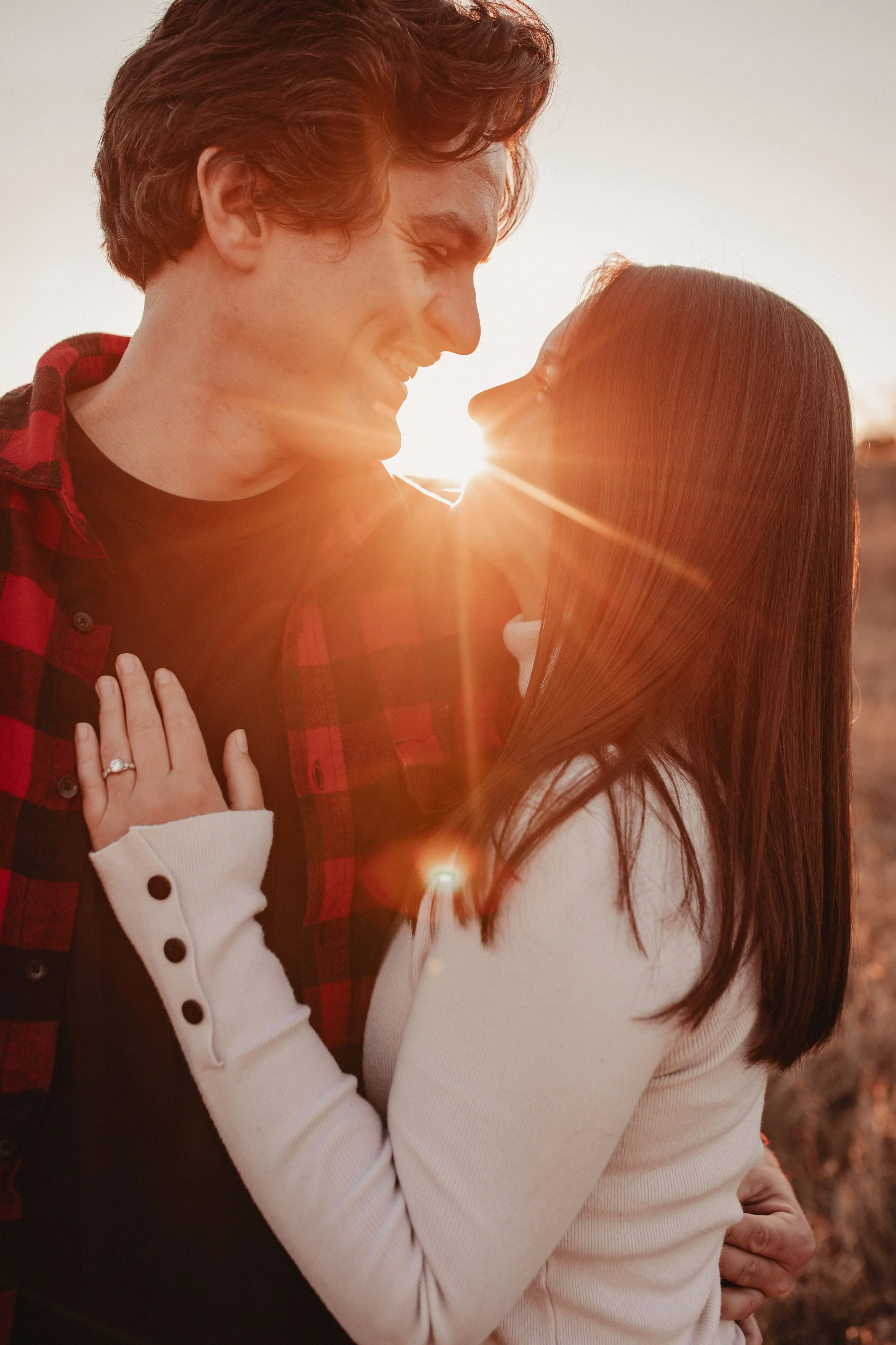 Engagement session in a field at a sunset