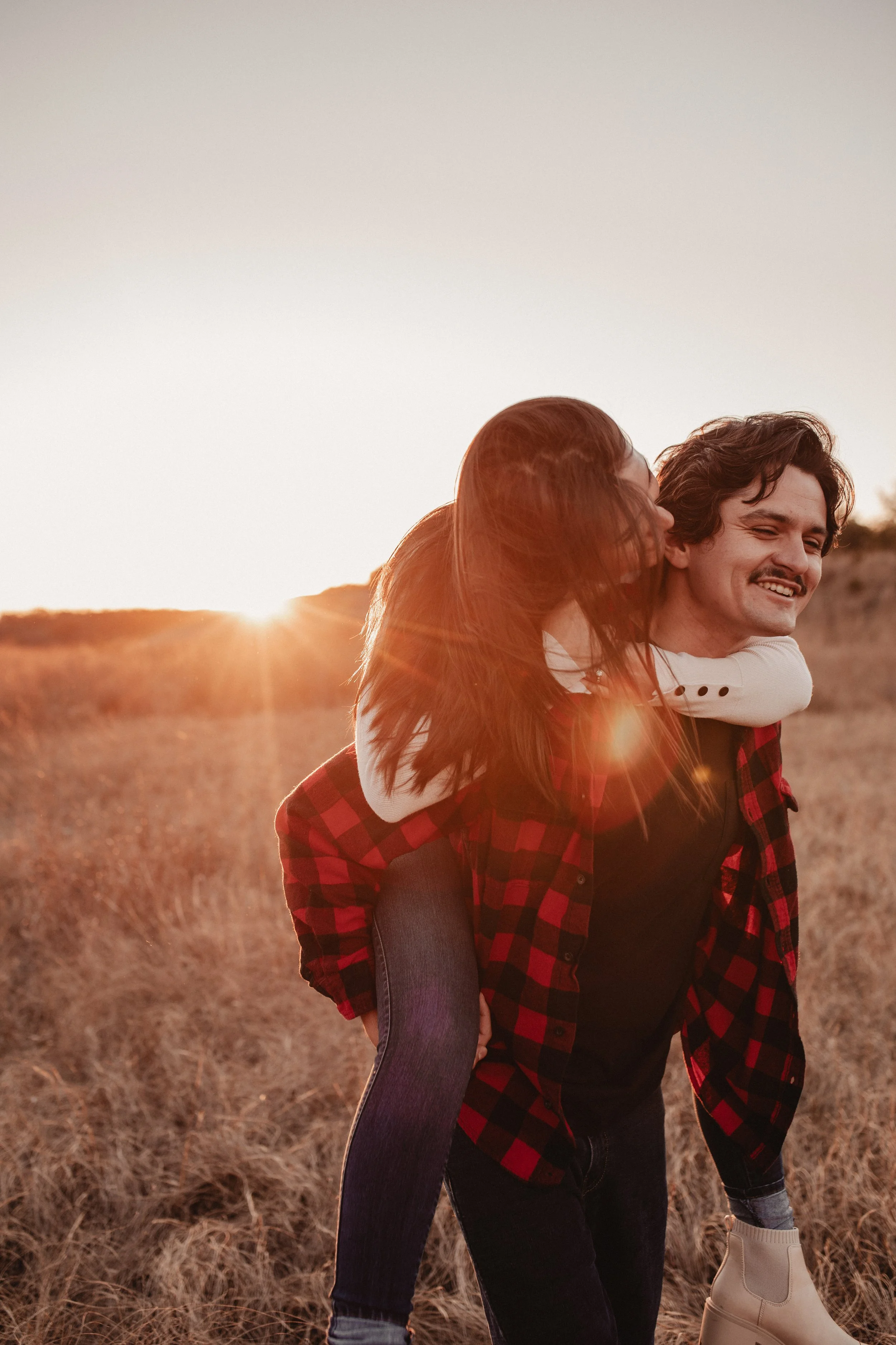 Engagement session in a field at a sunset