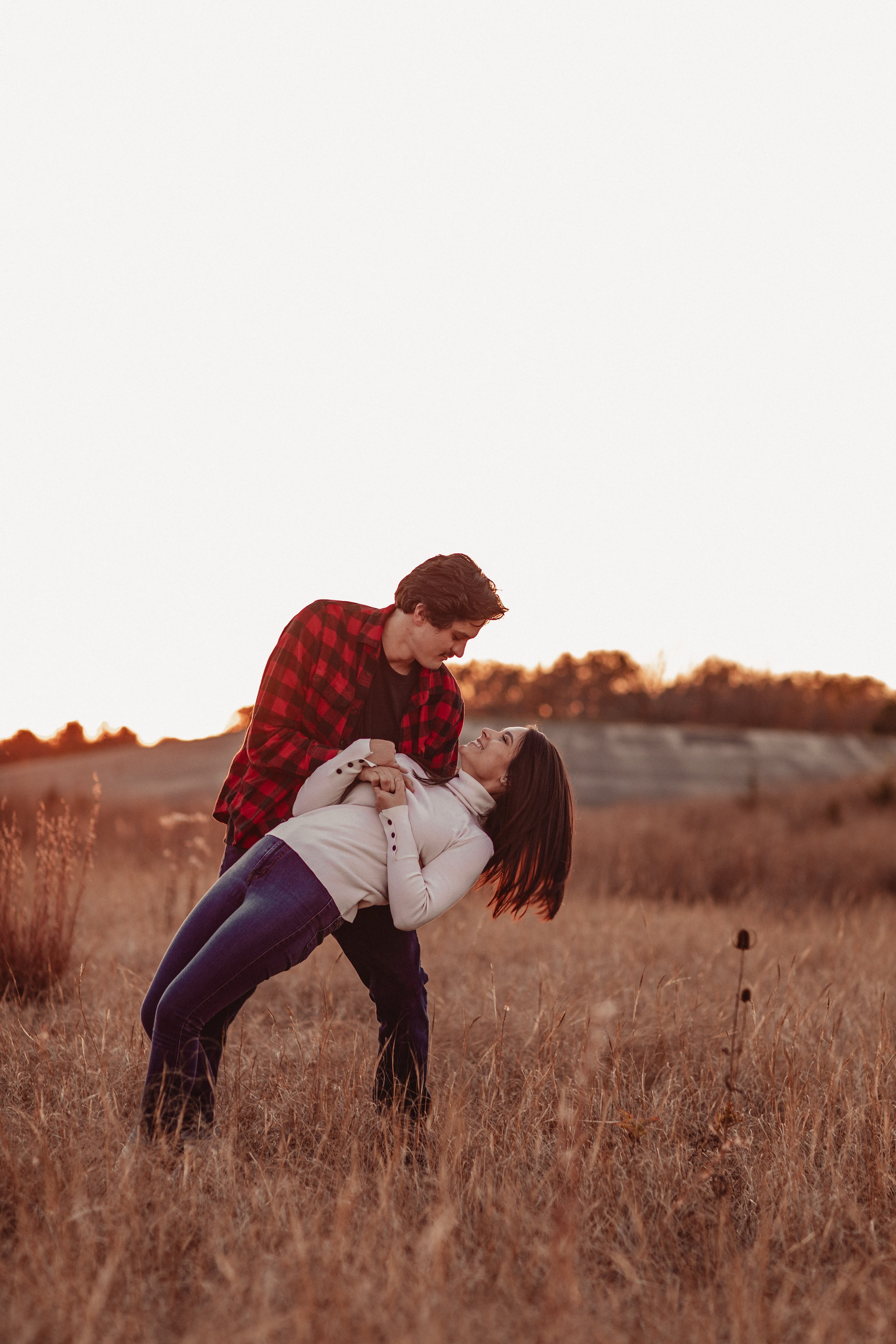 Engagement session in a field at a sunset