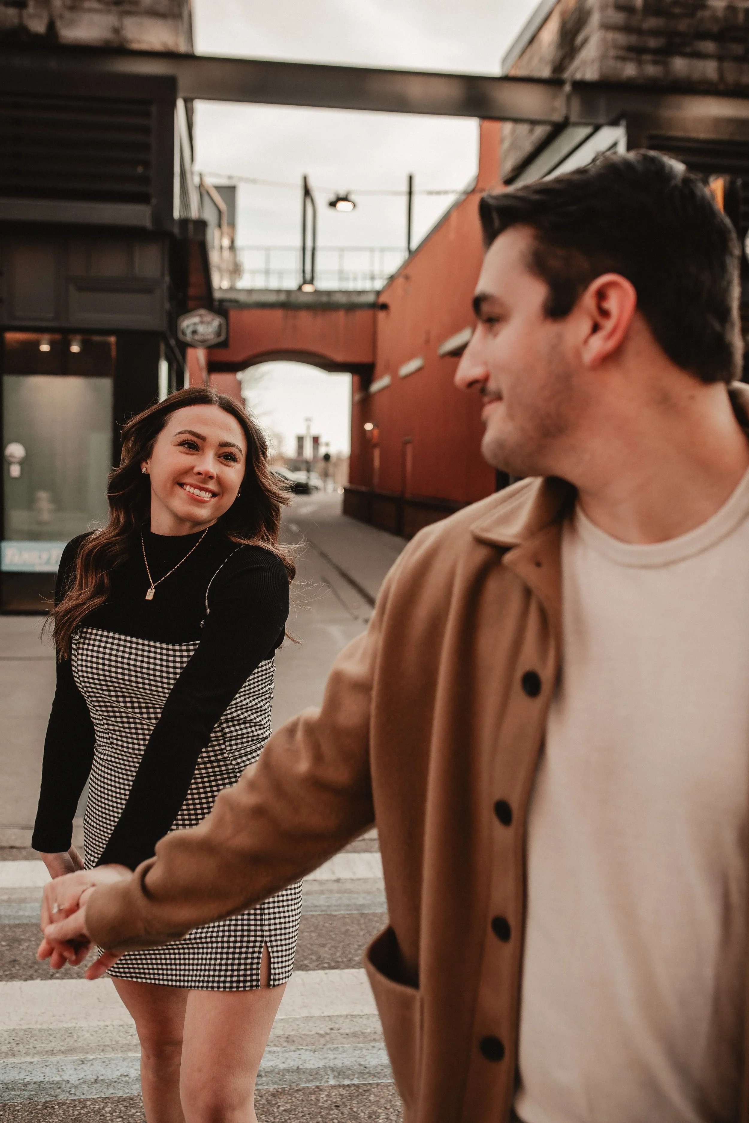 Candid engagement photo of a couple walking hand in hand in Cincinnati, Ohio, photographed by Sarah and Jordan of Every Atom Photography