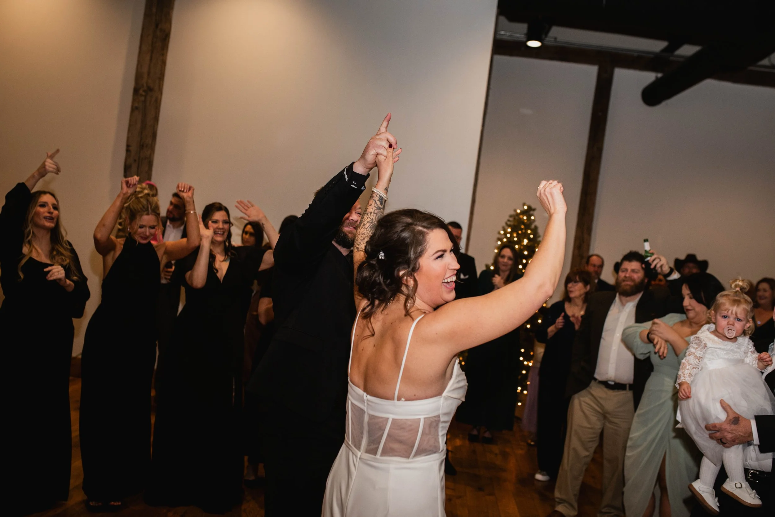 Bride and wedding guests celebrating on the dance floor during a reception at The Landing Event Center in Loveland, Ohio.