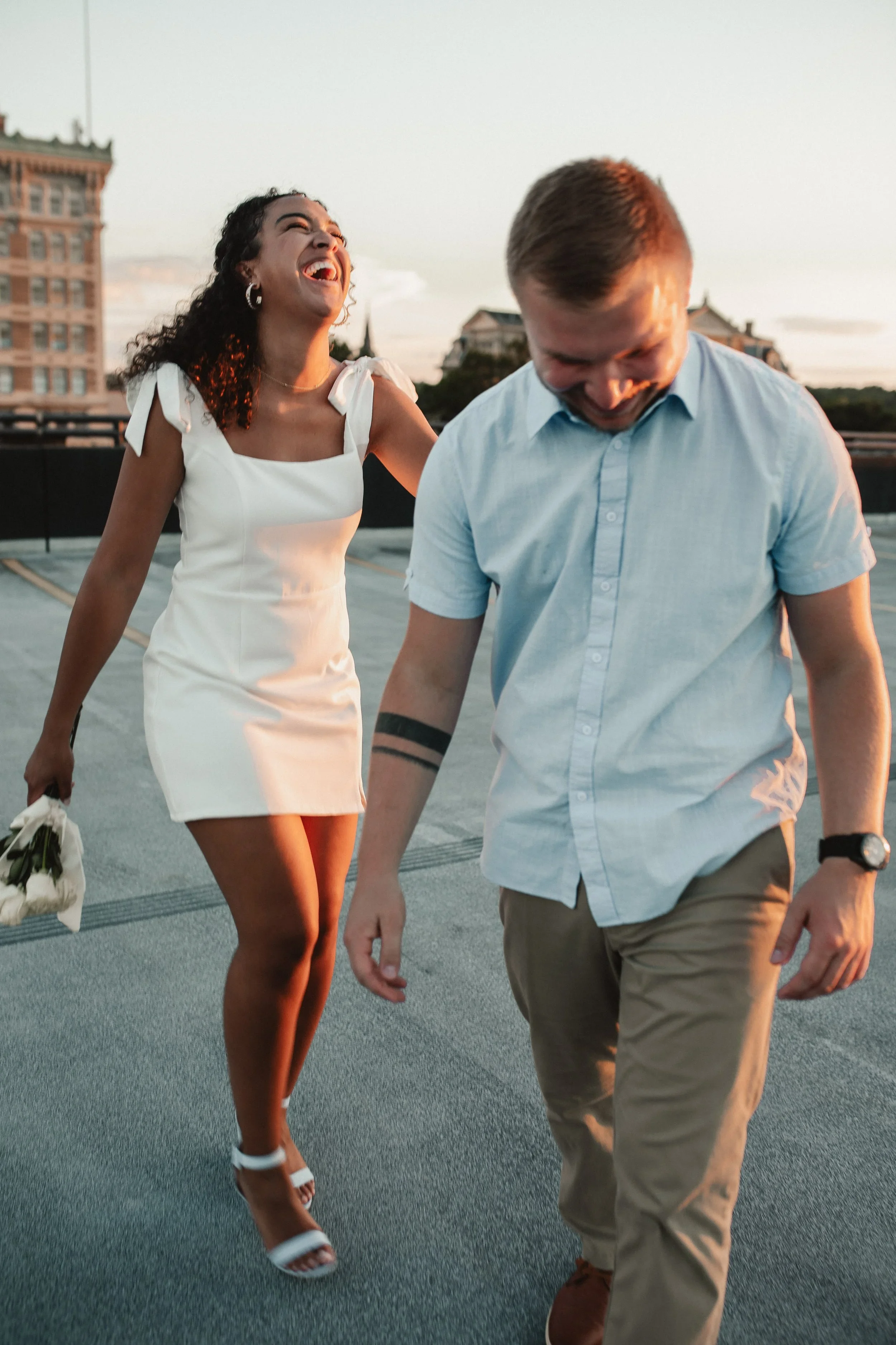 Candid engagement photo of a couple laughing and walking together during a Cincinnati engagement session photographed by Sarah and Jordan of Every Atom Photography