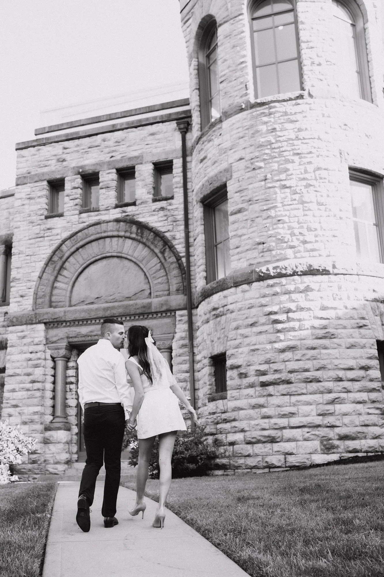 Black-and-white photograph of Kitty and Scott walking toward the Cincinnati Art Museum’s arched stone entrance.