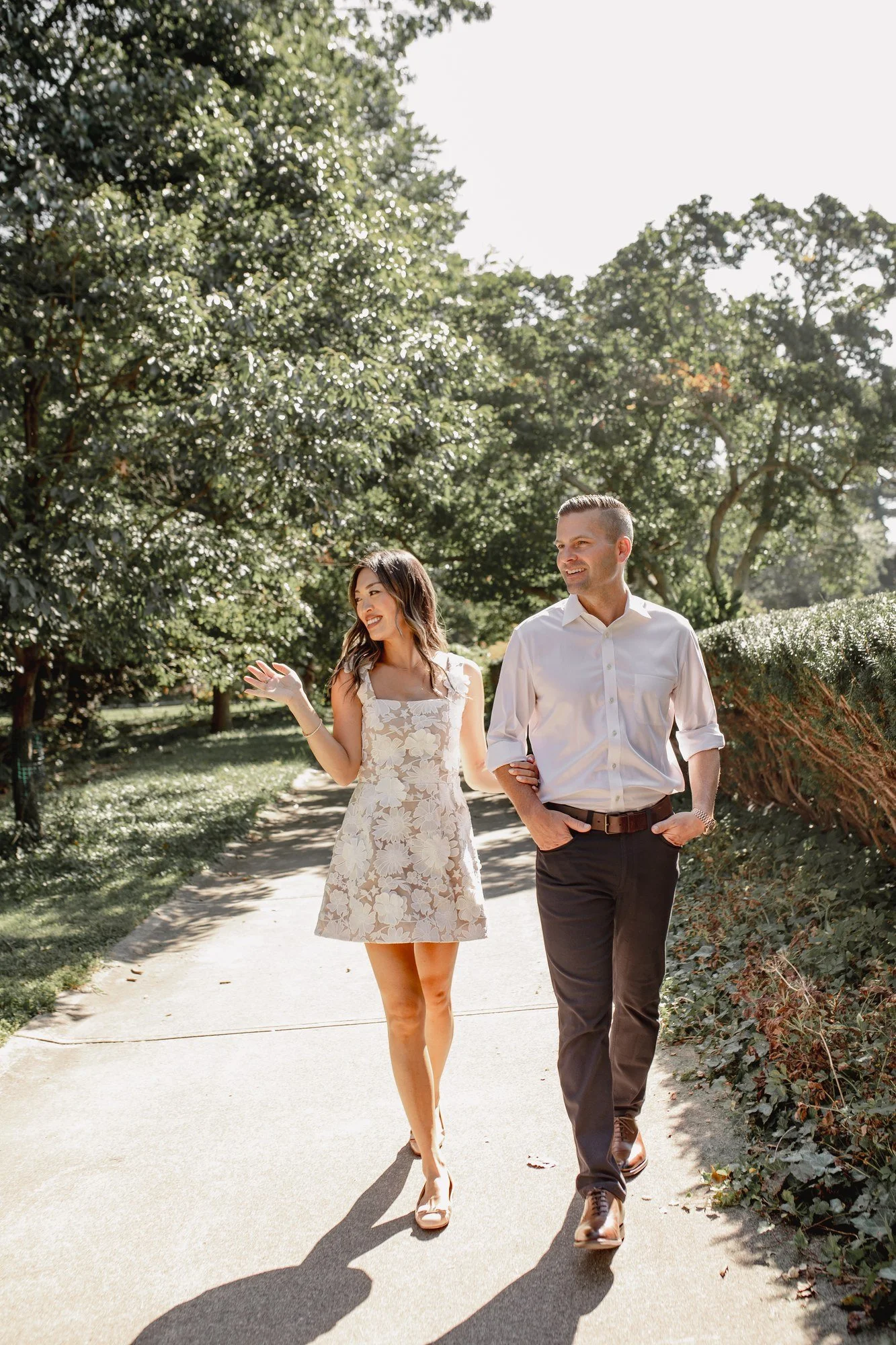Kitty and Scott walking together along a tree-lined path.