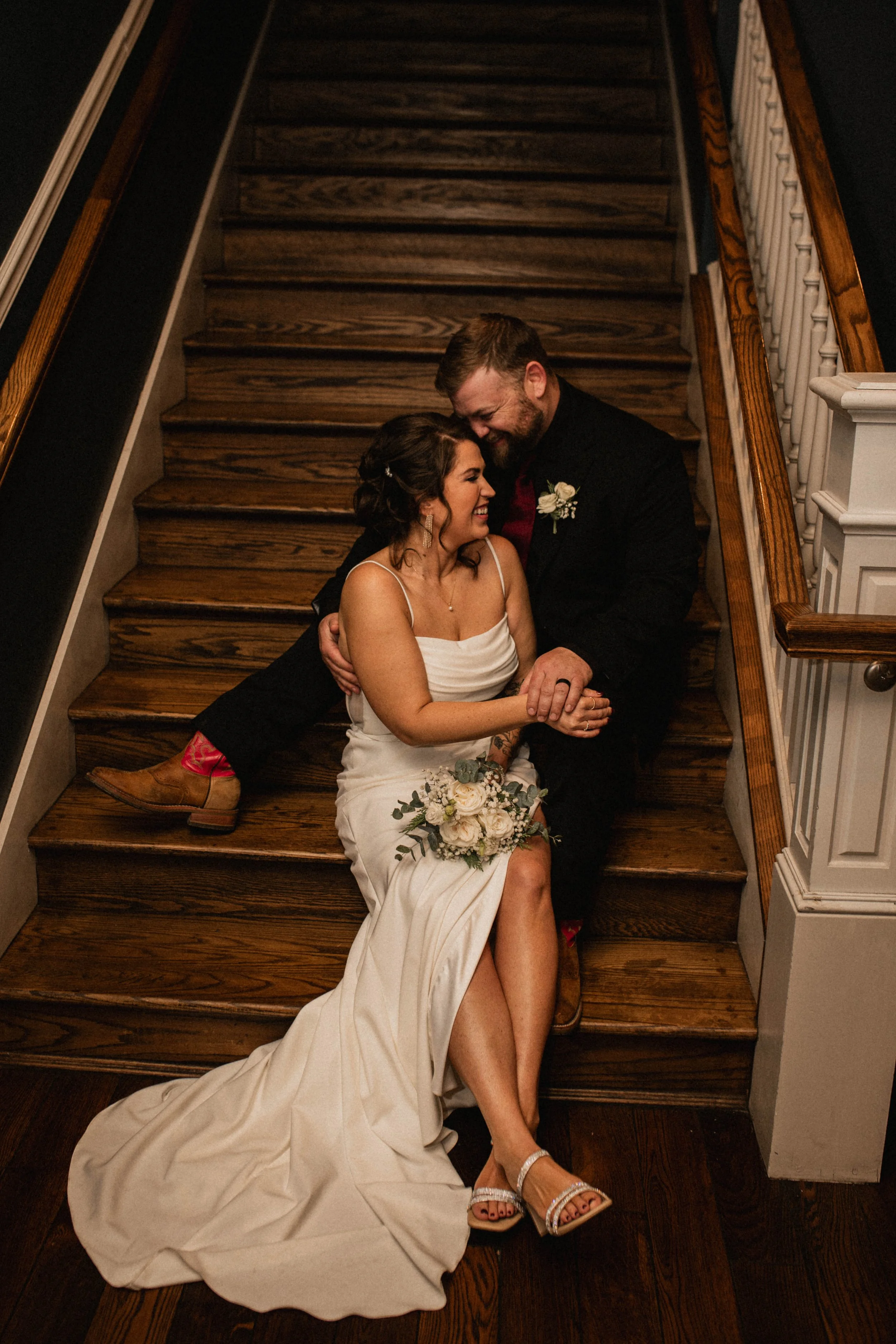 Newlyweds Tony and Kelsey sharing a moment on a staircase at The Landing Event Center wedding in Loveland, Ohio.