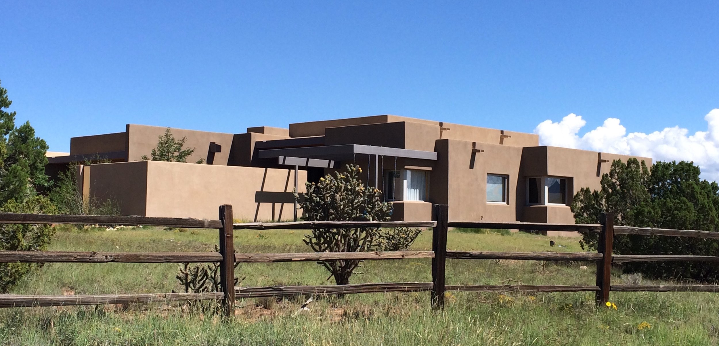 The homeowner sent this photo because he loves his house. Note the steel pergola that shades the west side of the guest bedroom and provides an armature for two swings for folks who loves to view the mountains and watch the horses pass by.