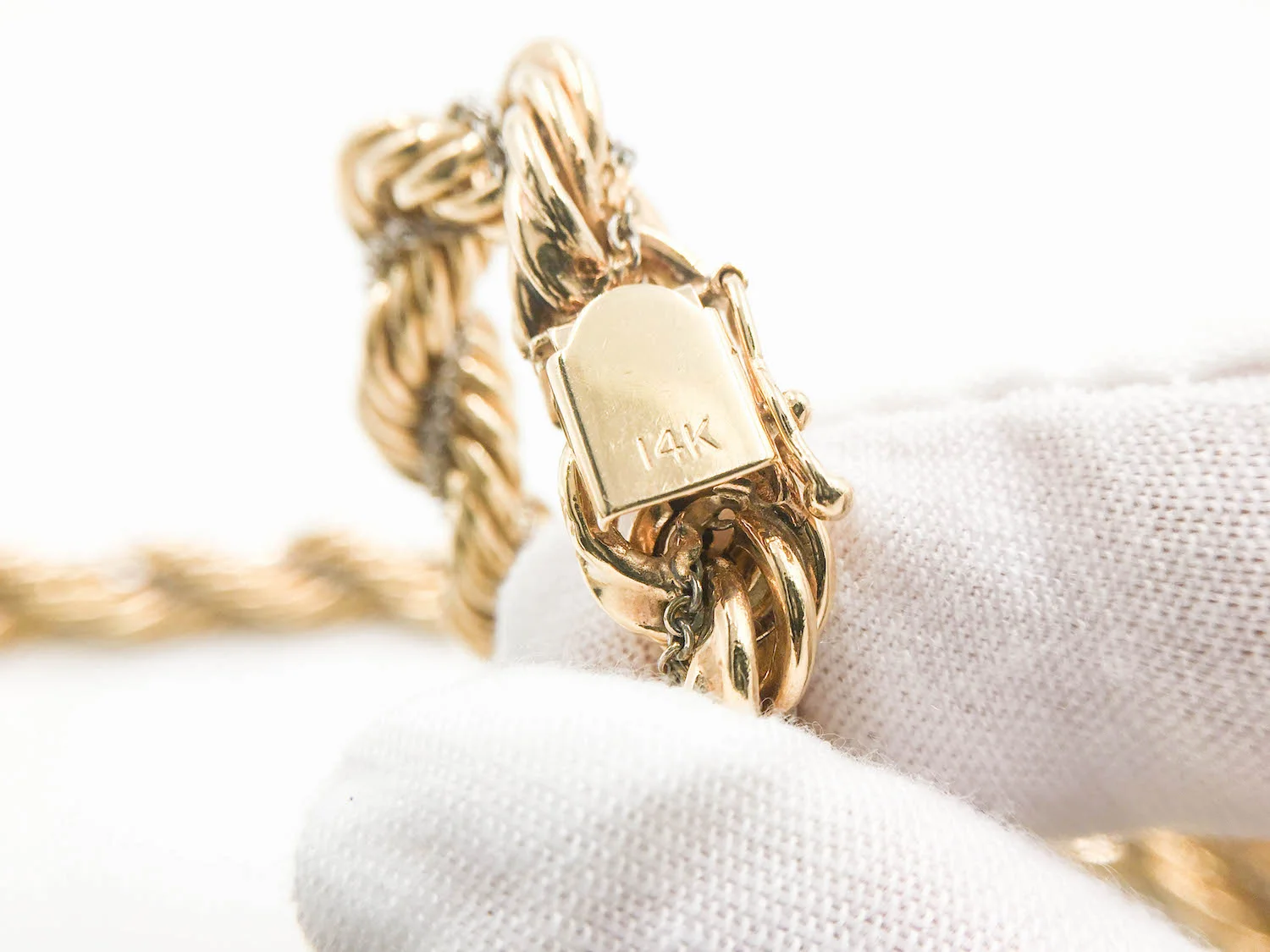 14K stamp on a rope chain's clasp identifies it's pure gold percentage.