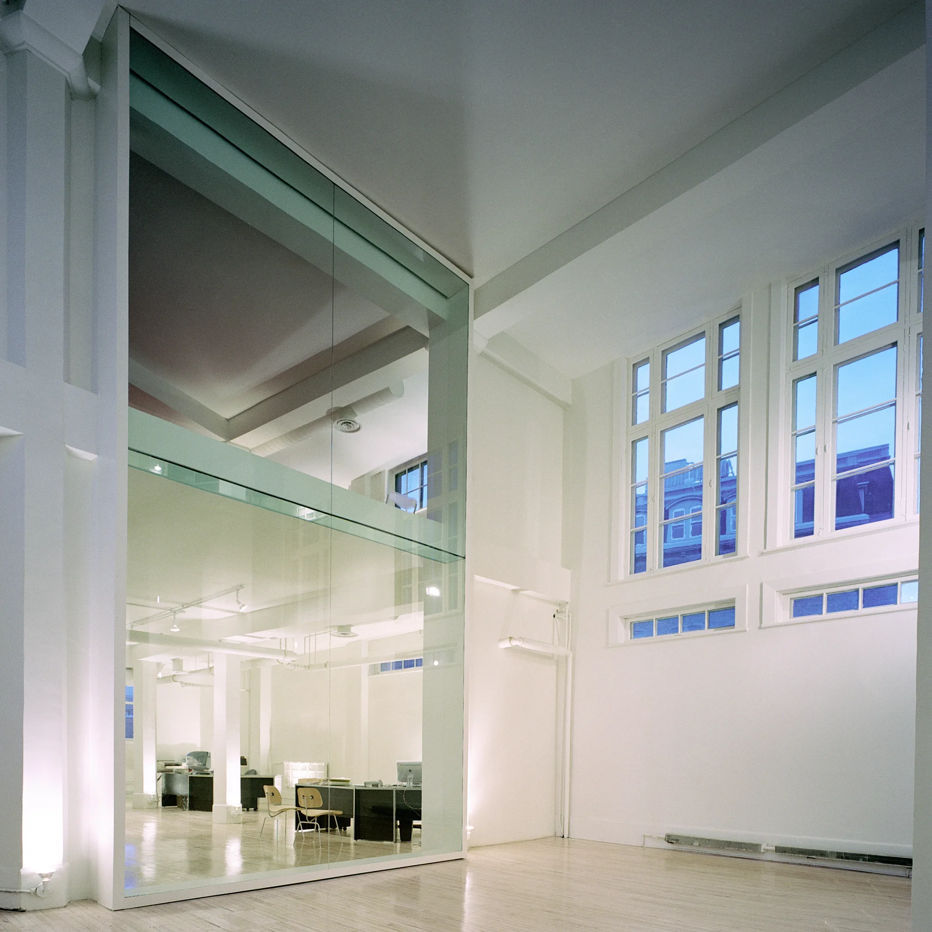 Les fenêtres originales sur les côtés sont découvertes. Une nouvelle paroi de verre sépare les bureaux de l’espace événementiel. Crédit photo © Marc Cramer