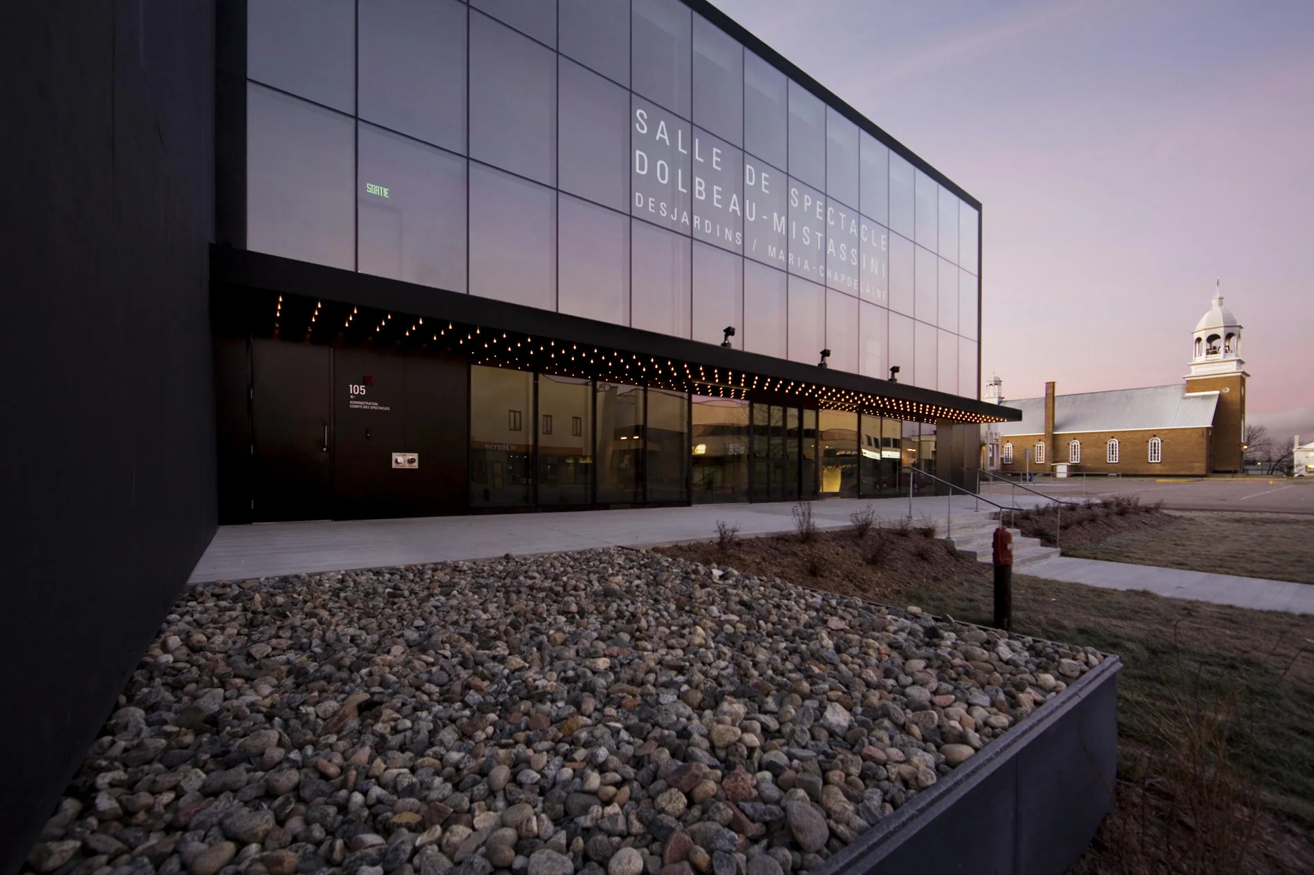 Vue de la façade avant avec la marquise traditionnelle. Le titre du bâtiment est écrit sur le vitrage. Crédit photo : Marc Gibert – adecom.ca