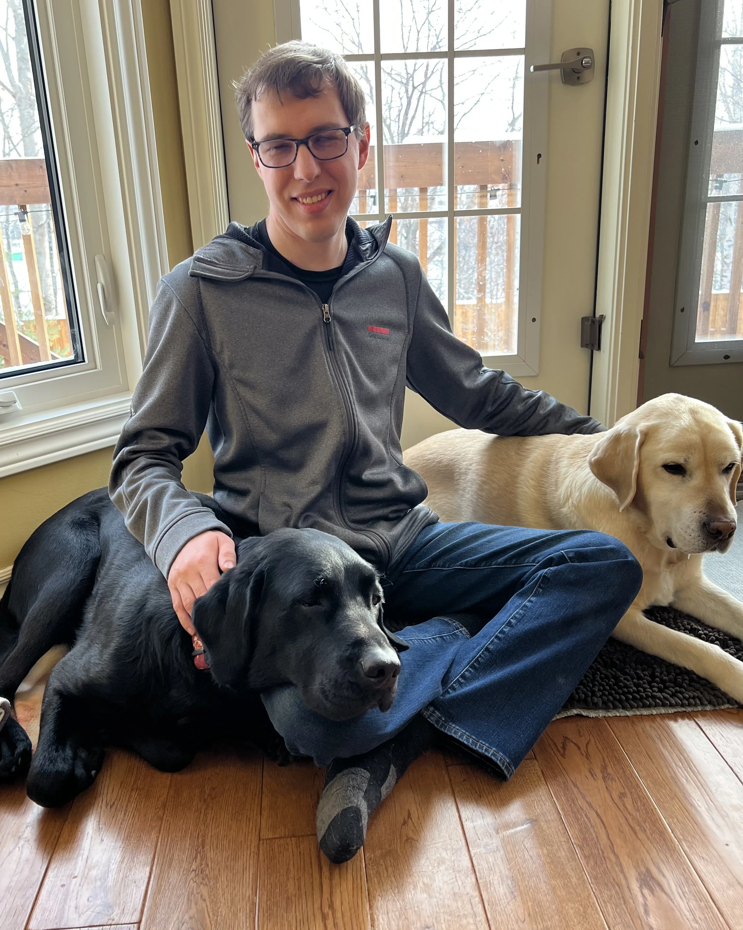Photo of Chris sitting with his two dogs