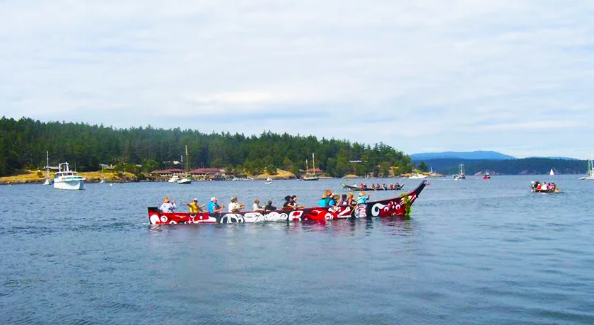 Tribal canoes arriving on San Juan Island. 