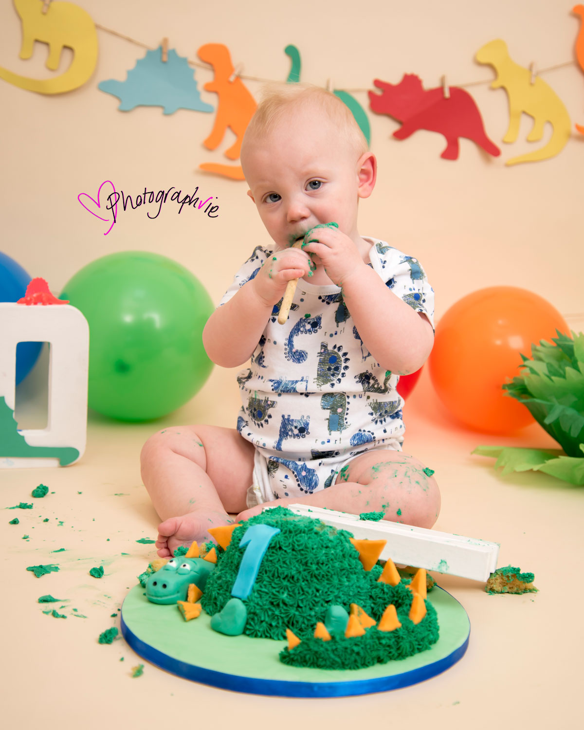 Cake_smash_photography_Ely_Cambridgeshire_first_birthday_dinosaur_themed_boy_eating_cake.jpg